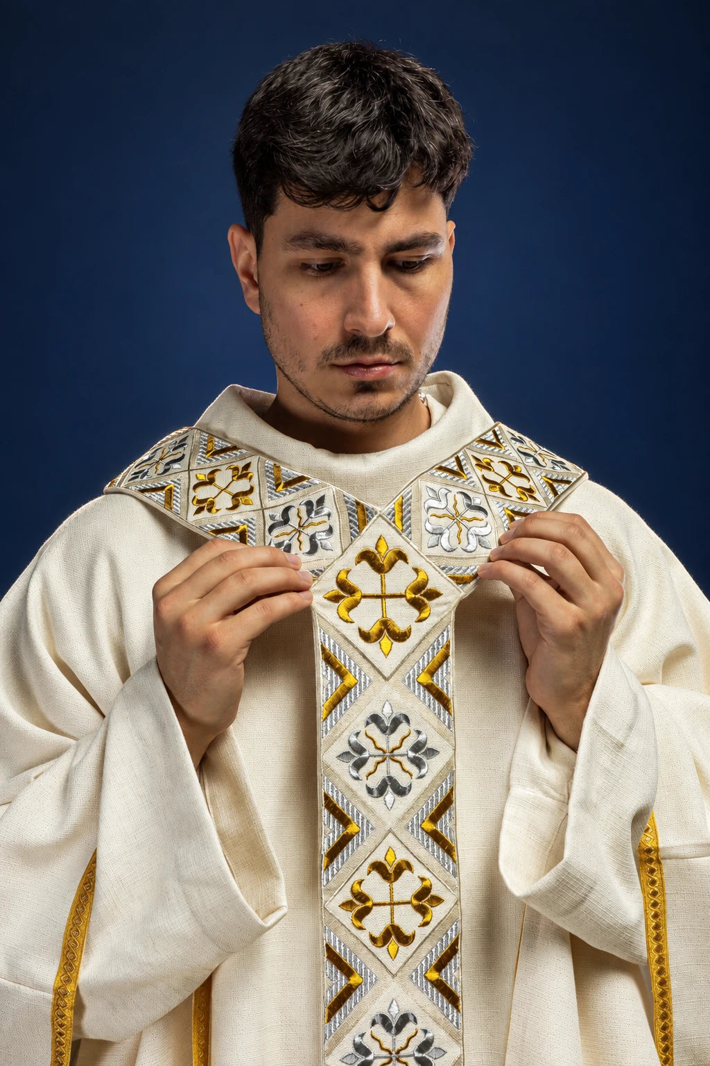 Front view of cream chasuble with ornate gold and gray embroidered orphrey and cross motifs