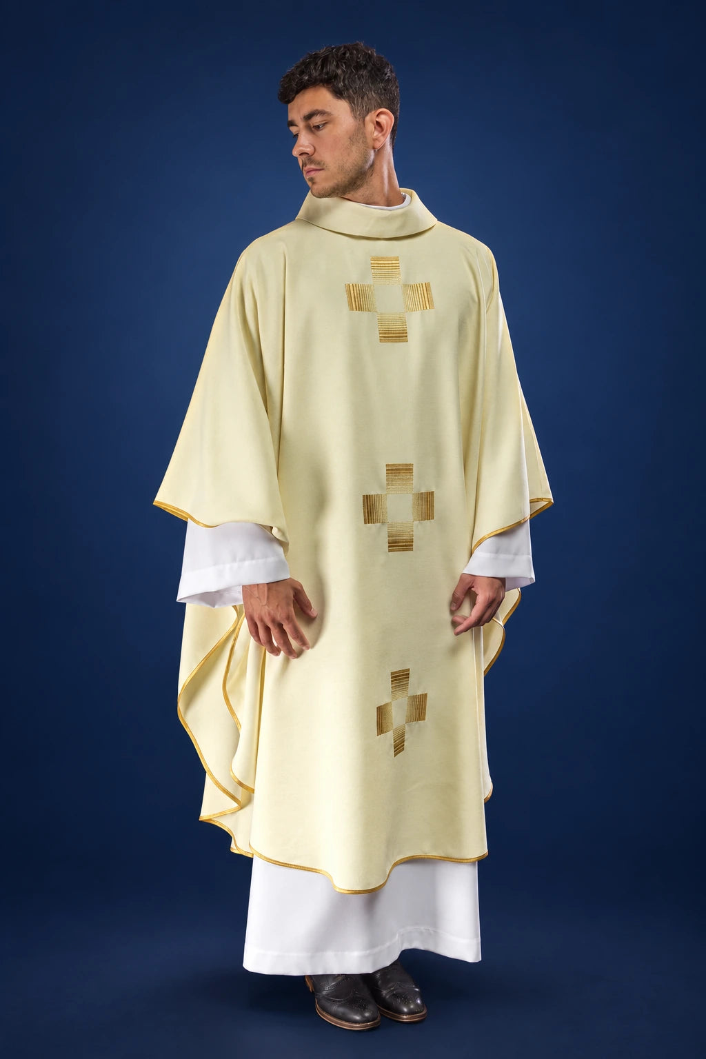 Front view of a cream chasuble with three embroidered gold crosses and gold trim on the edges