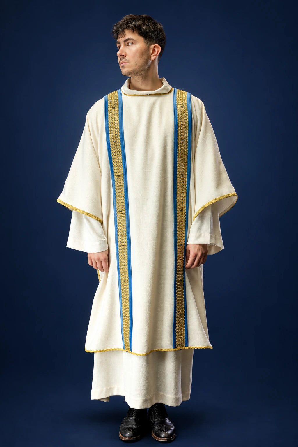 Front view of a cream dalmatic with blue-and-gold vertical bands and gold trim, worn over a white alb.