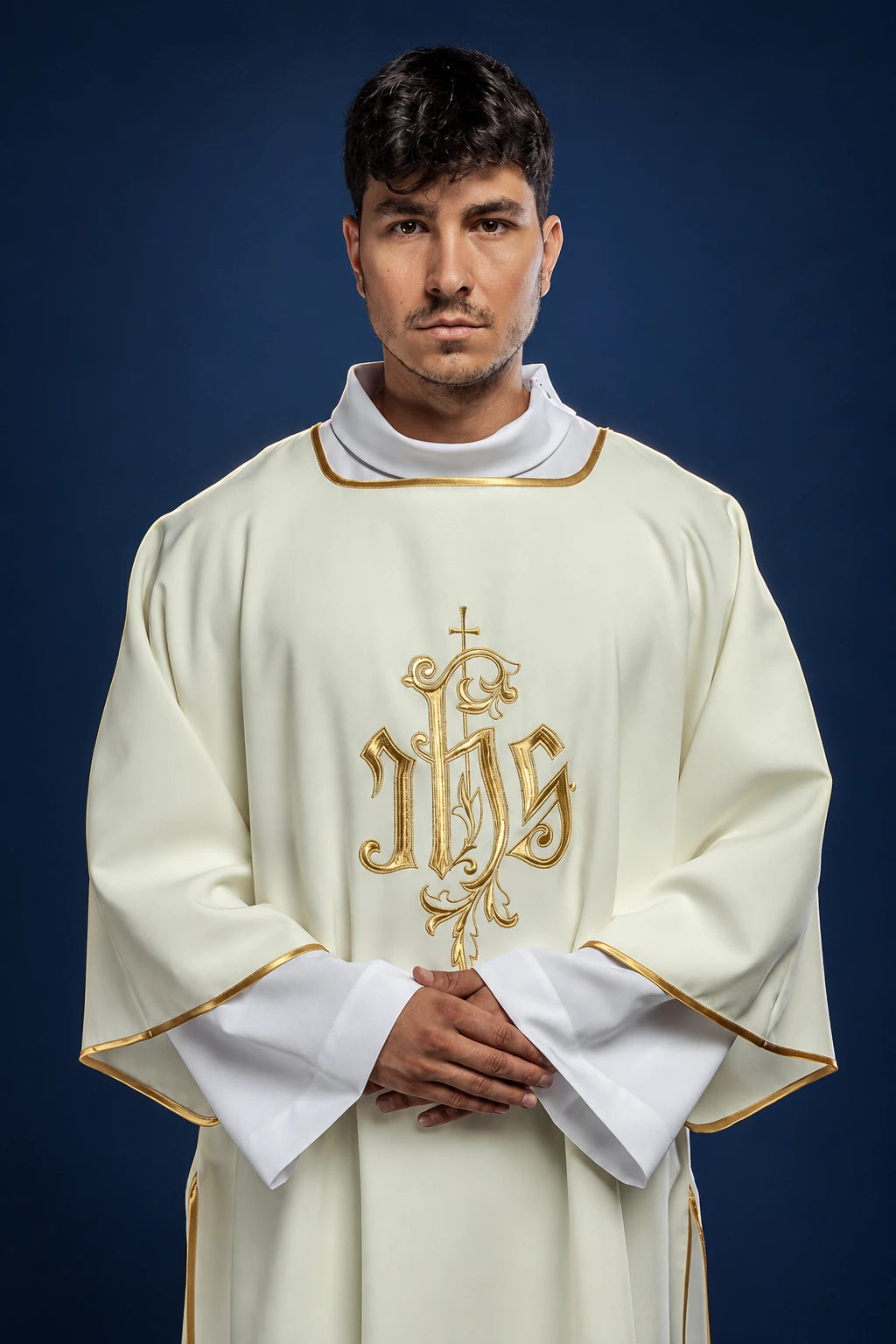 Front view of a cream dalmatic with gold trim and large gold IHS embroidery on the chest