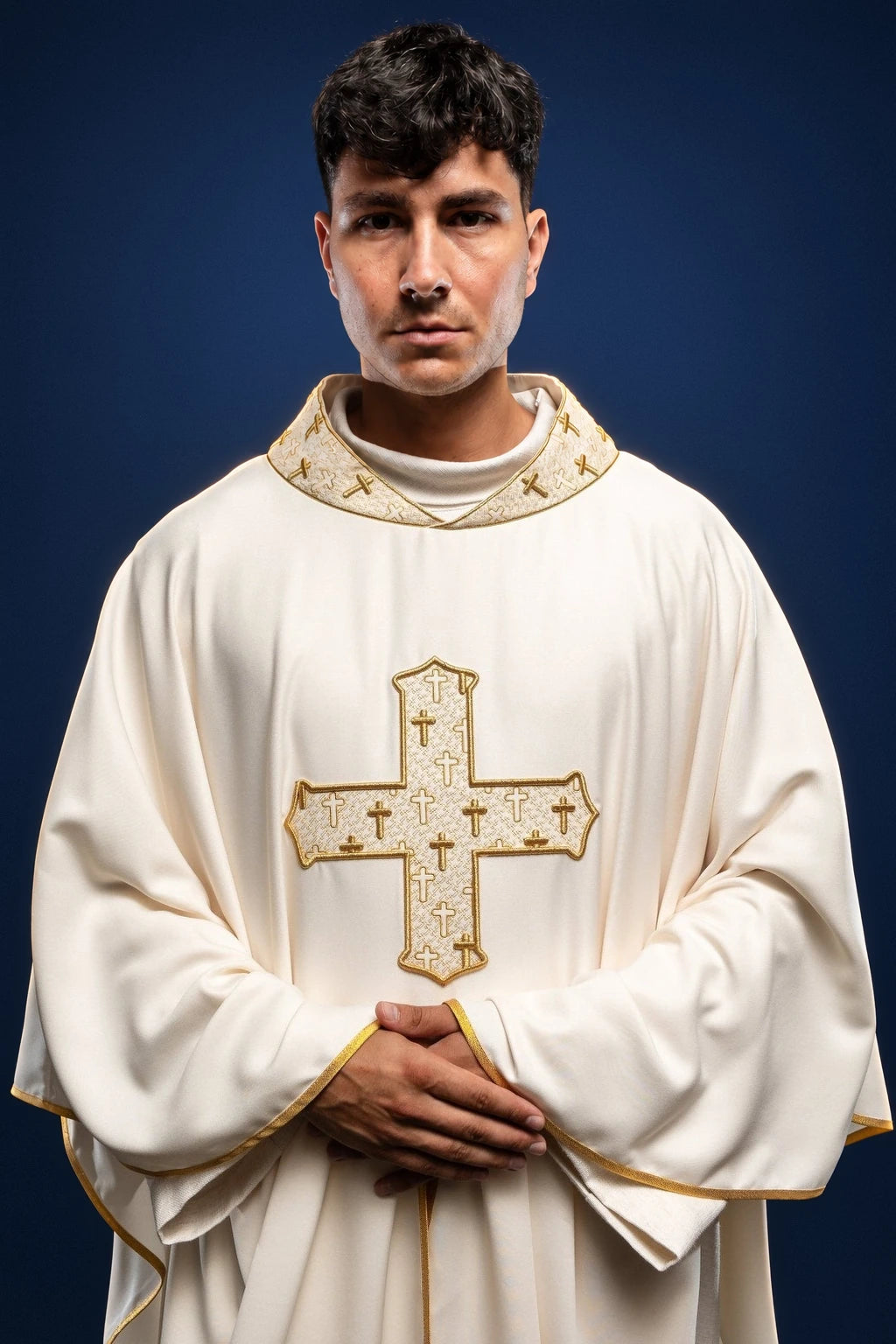 Front view of an ecru chasuble with gold-embroidered cross and matching embroidered collar