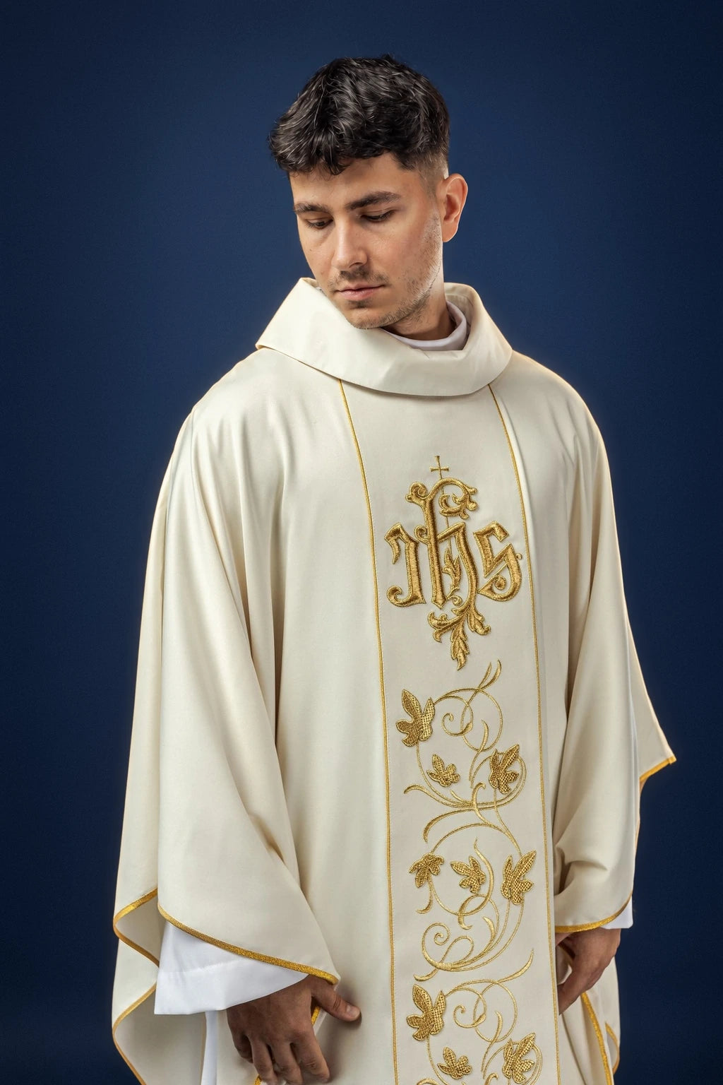 Front view of an ecru chasuble with gold floral orphrey and IHS monogram detail