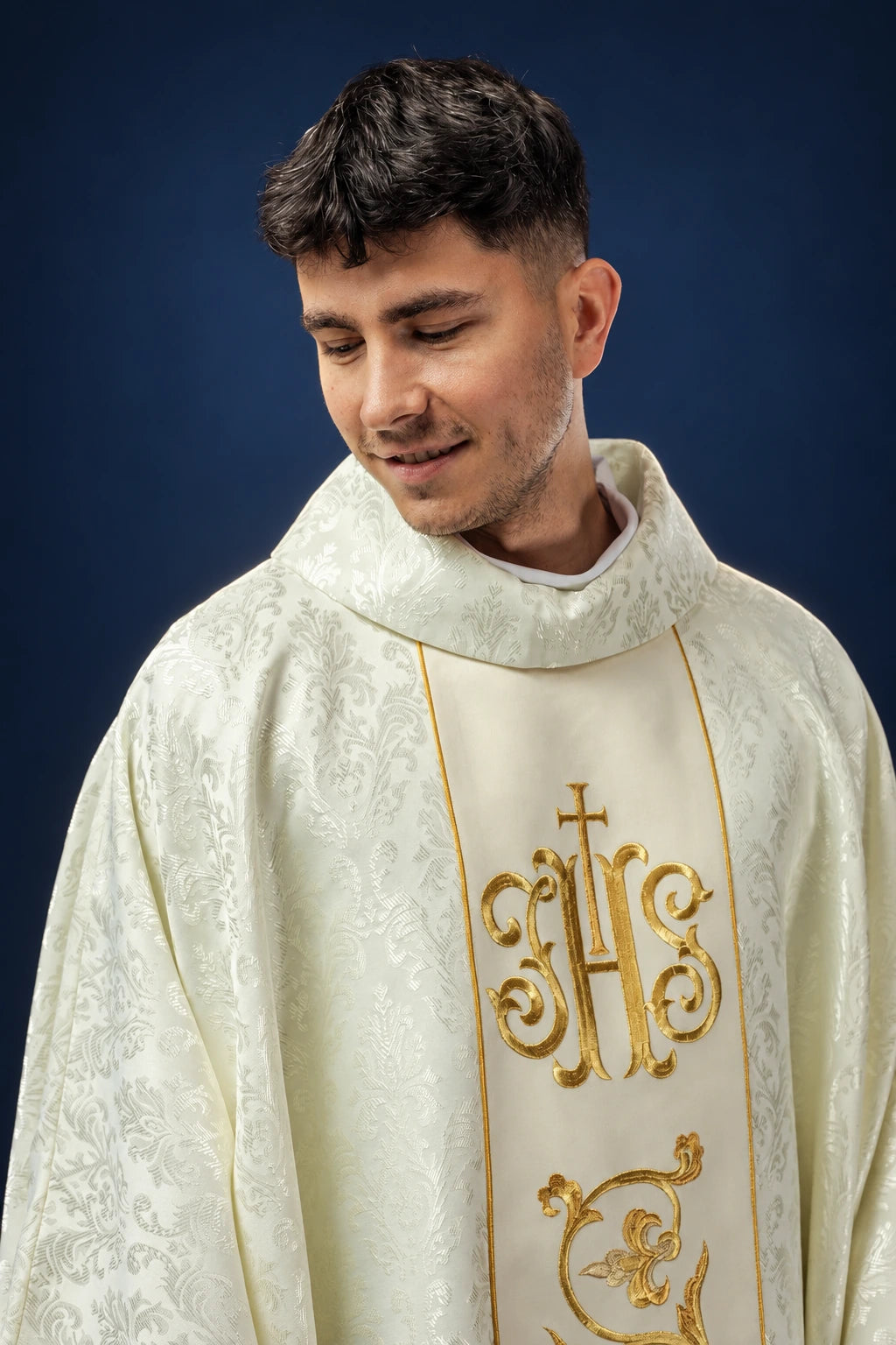 Front view of ecru chasuble with gold IHS orphrey and floral woven pattern