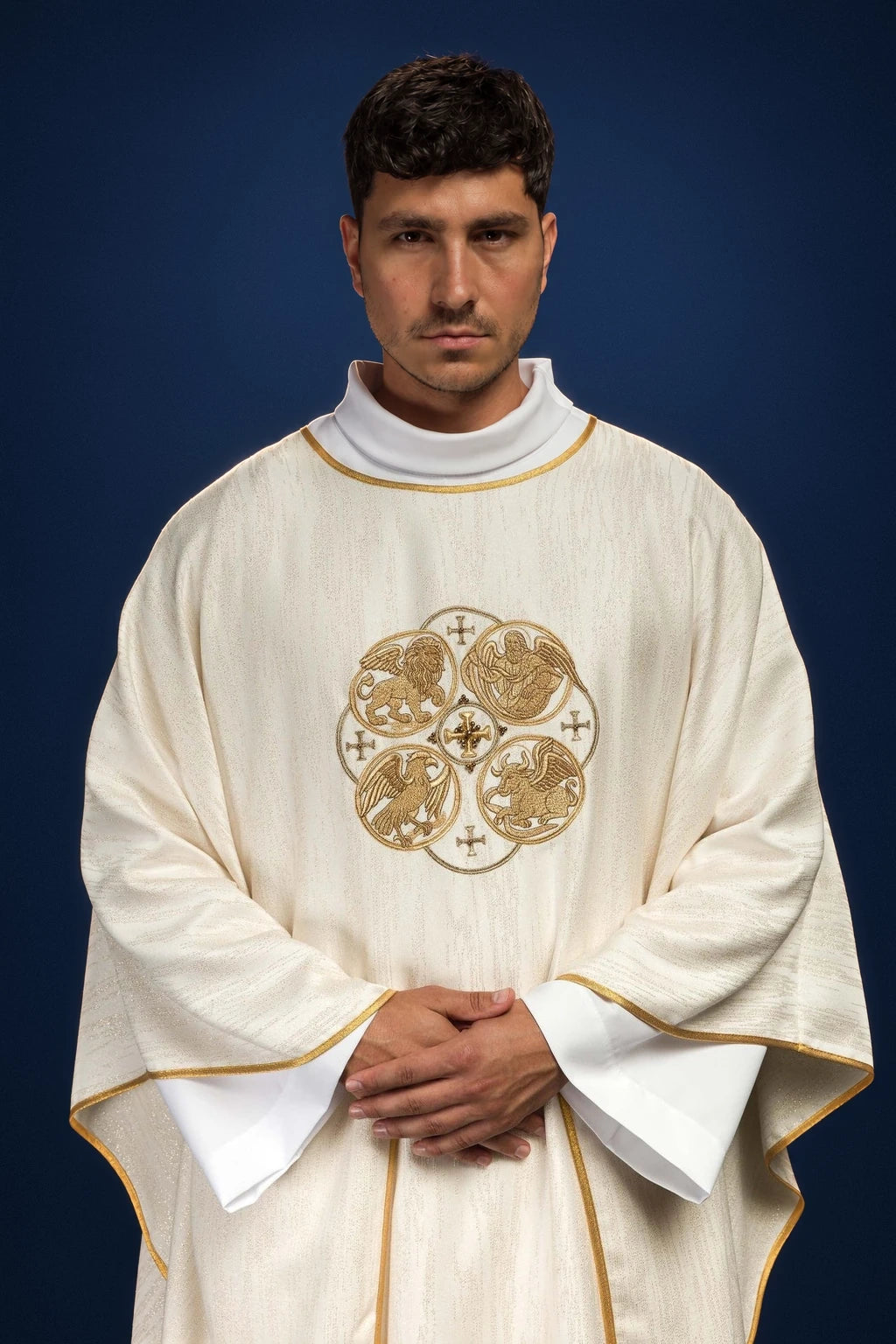 Front view of an ecru chasuble with gold trim and central embroidery of the four Evangelists