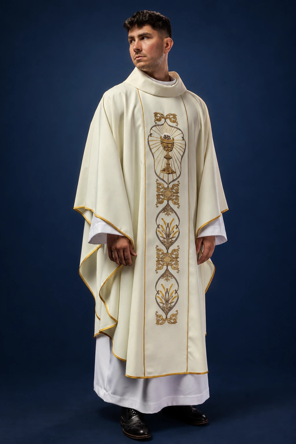 Front view of an ecru chasuble with gold trim and central IHS chalice embroidery