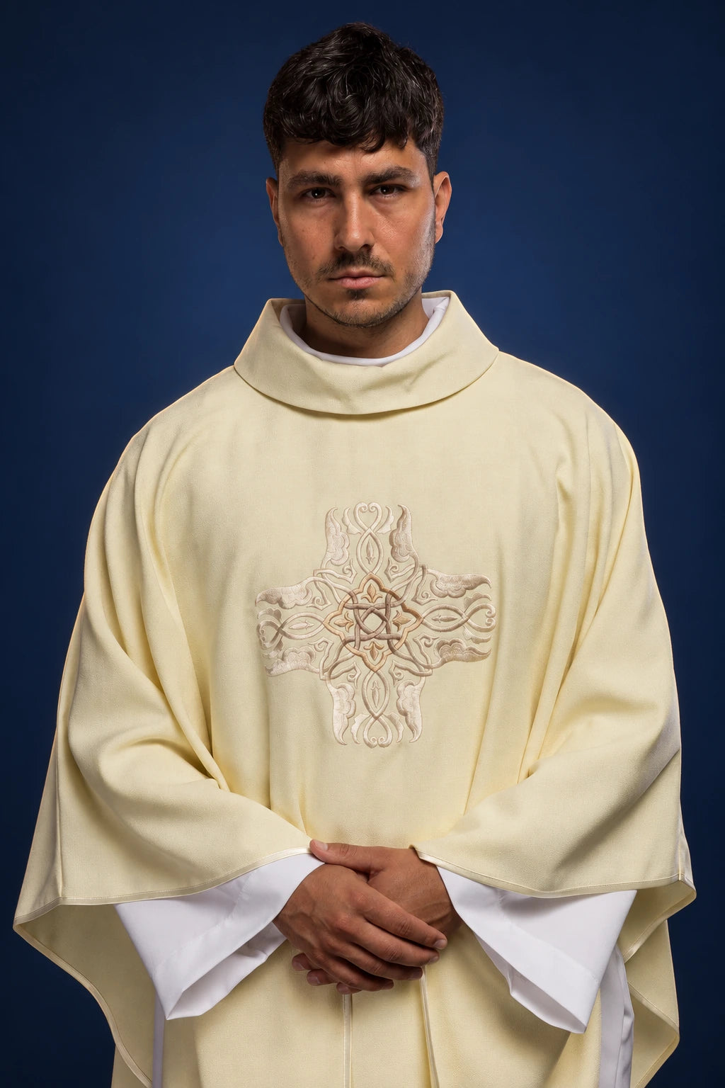 Front view of an ecru chasuble with a large embroidered gold cross on the chest