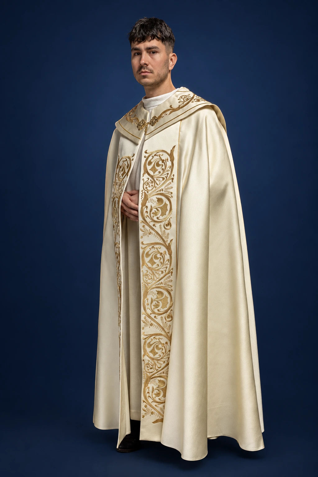 Front view of an ecru cope with gold IHS embroidery and ornate vertical orphrey trim