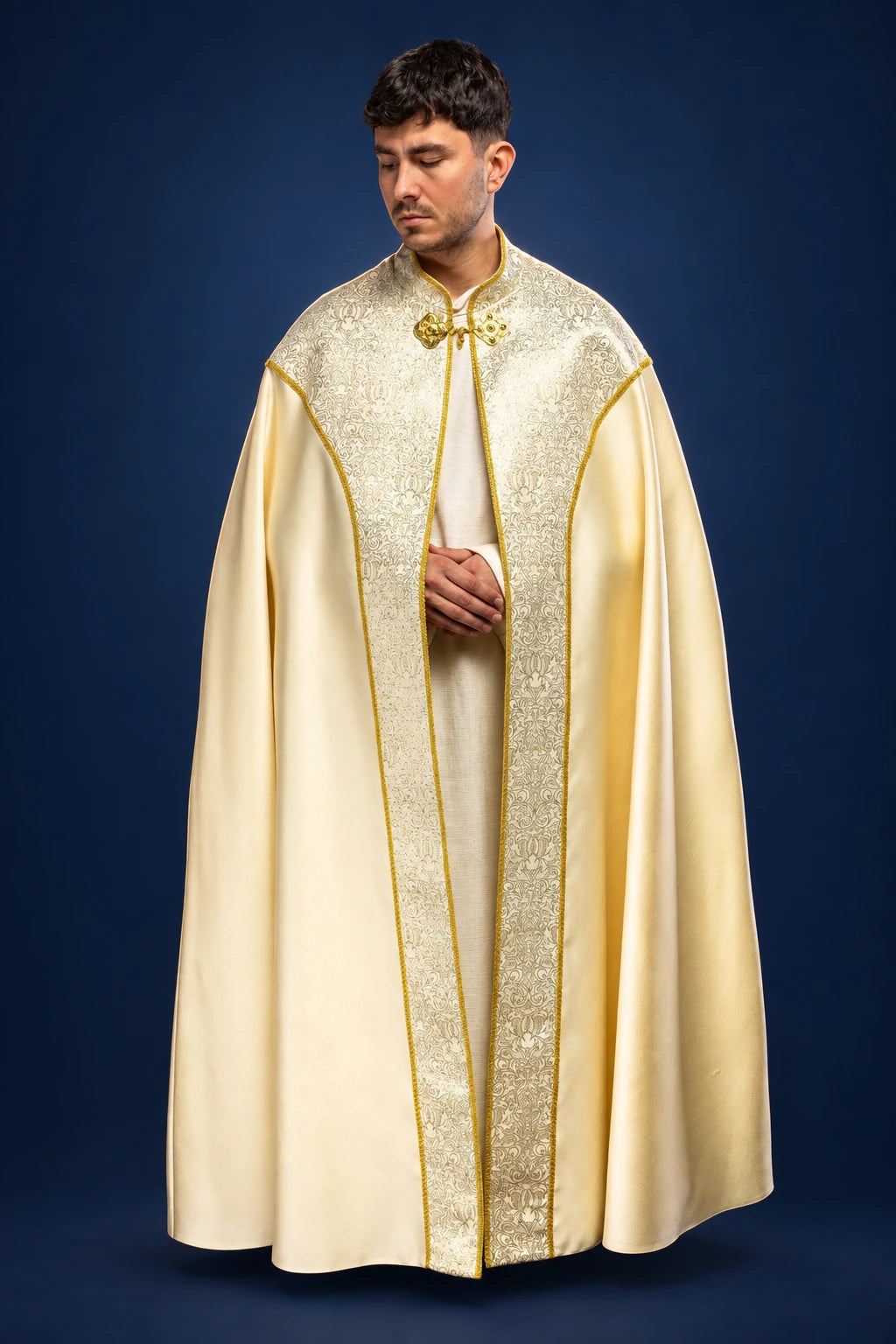 Front view of an ecru cope with gold jacquard panel and embroidered trim