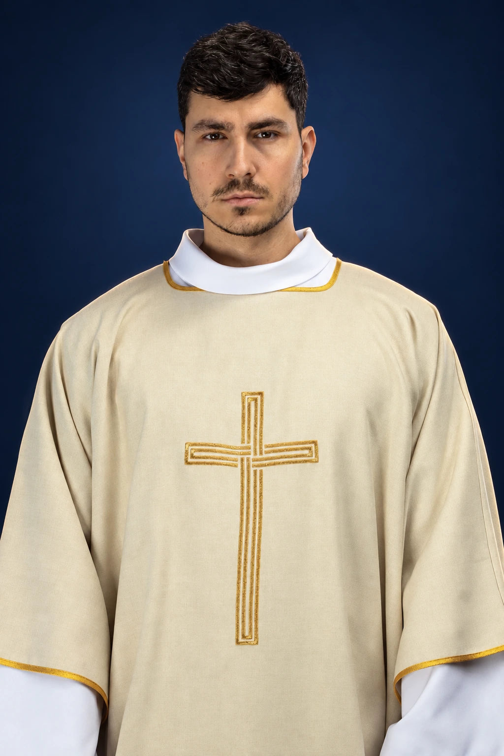 Front view of an ecru dalmatic with gold trim and an embroidered gold cross on the chest