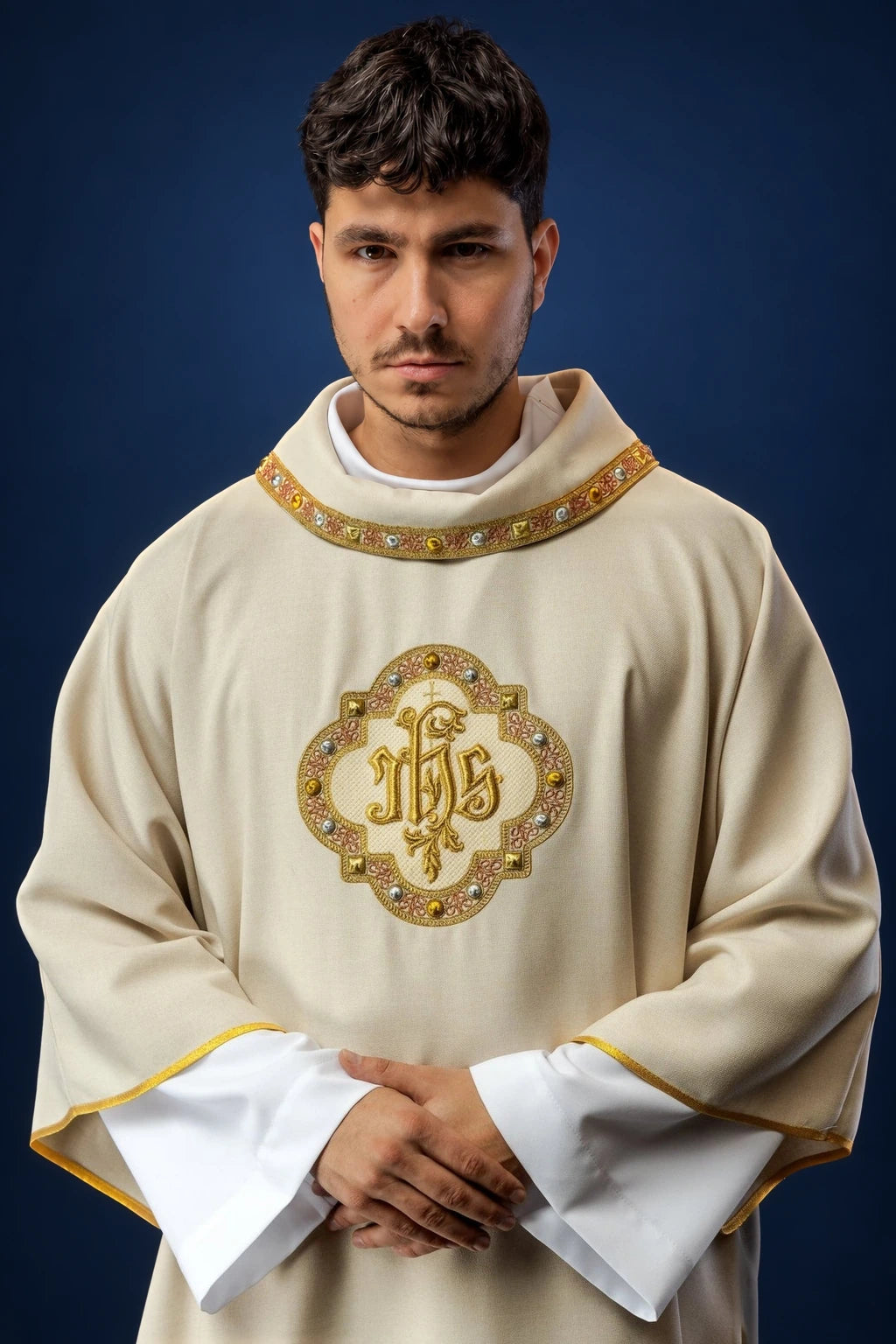 Front view of an ecru dalmatic with gold-trimmed collar and centered IHS emblem