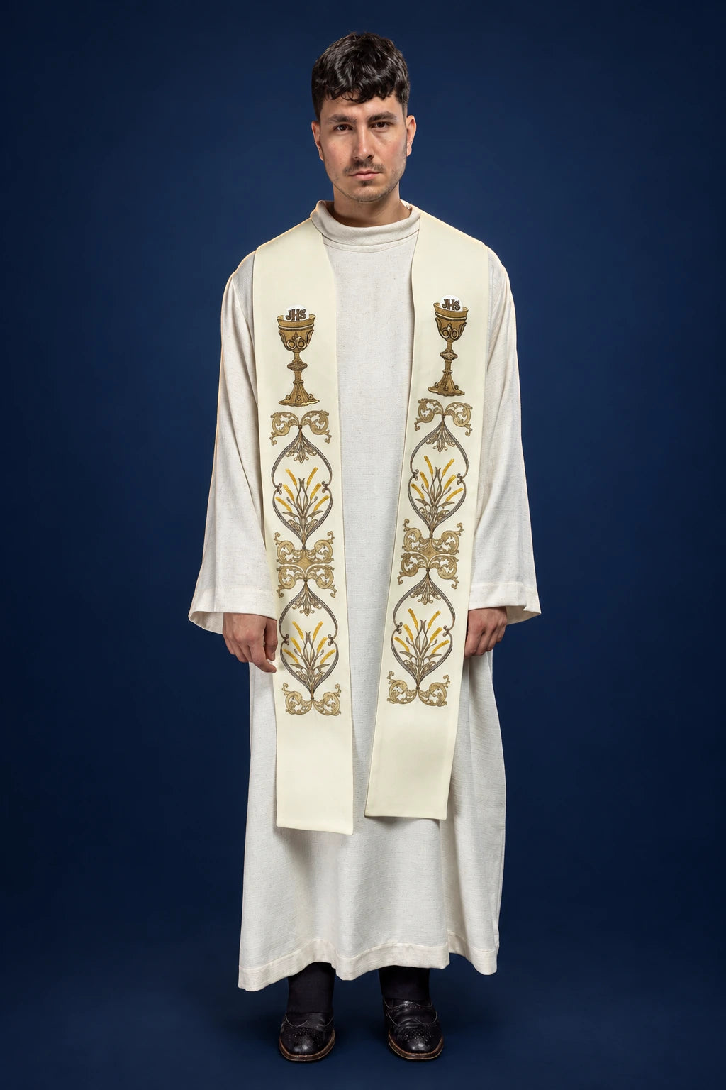 Front view of an ecru priest stole with gold IHS chalice embroidery, worn over a white alb