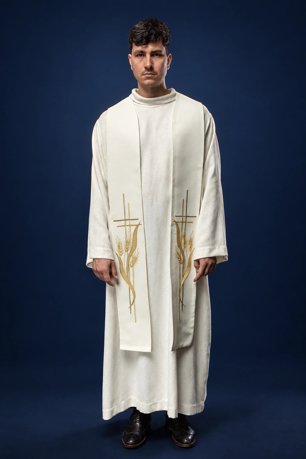 Front view of an ecru priest stole with gold wheat and cross embroidery, worn over a white alb