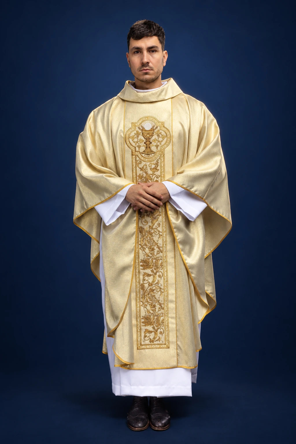 Front view of a gold chasuble with vertical chalice embroidery and wide draping sleeves
