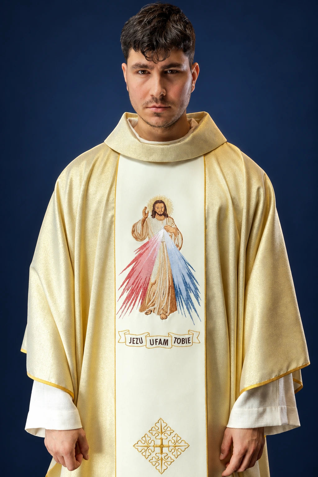 Front view of a gold chasuble with white panel, Divine Mercy embroidery, and IHS cross motif near the hem