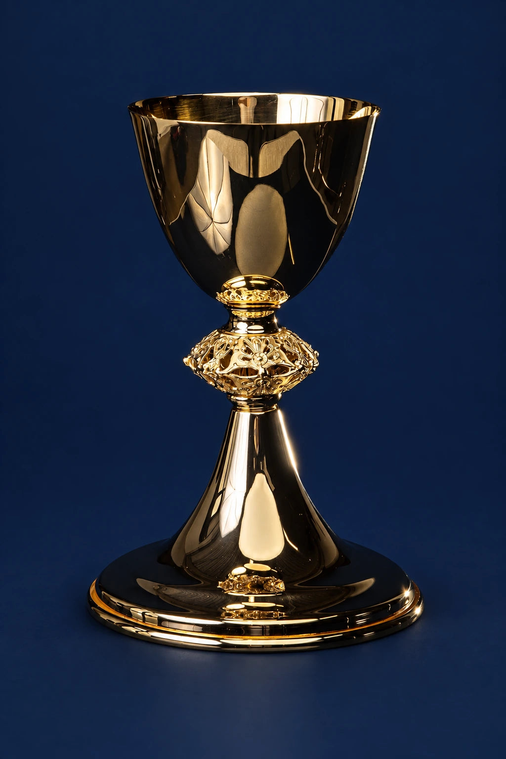 Front view of a gold-plated brass chalice with flared cup and ornate stem on a round base
