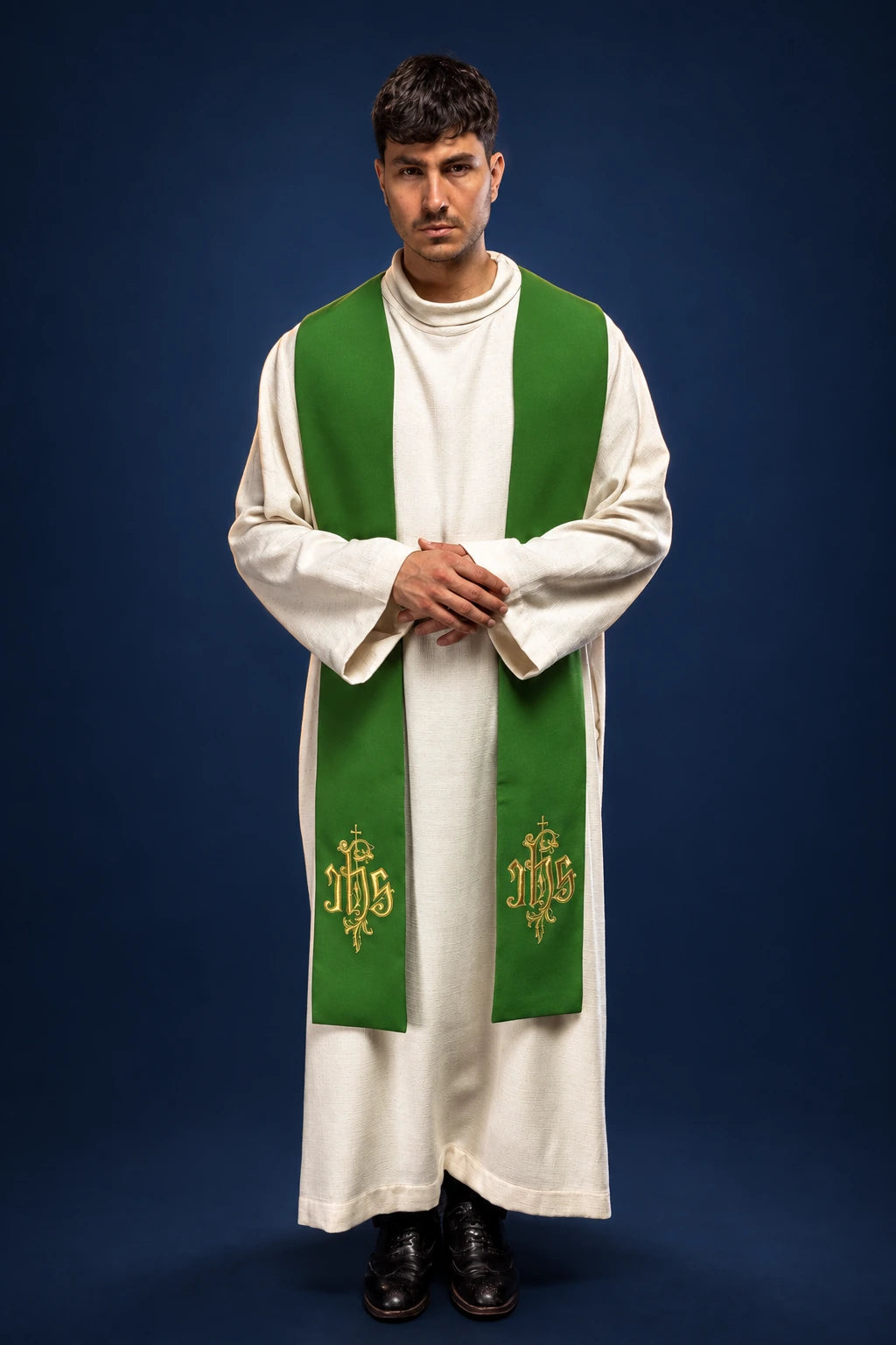 Front view of a green Catholic stole with gold IHS embroidery, worn over a white alb.