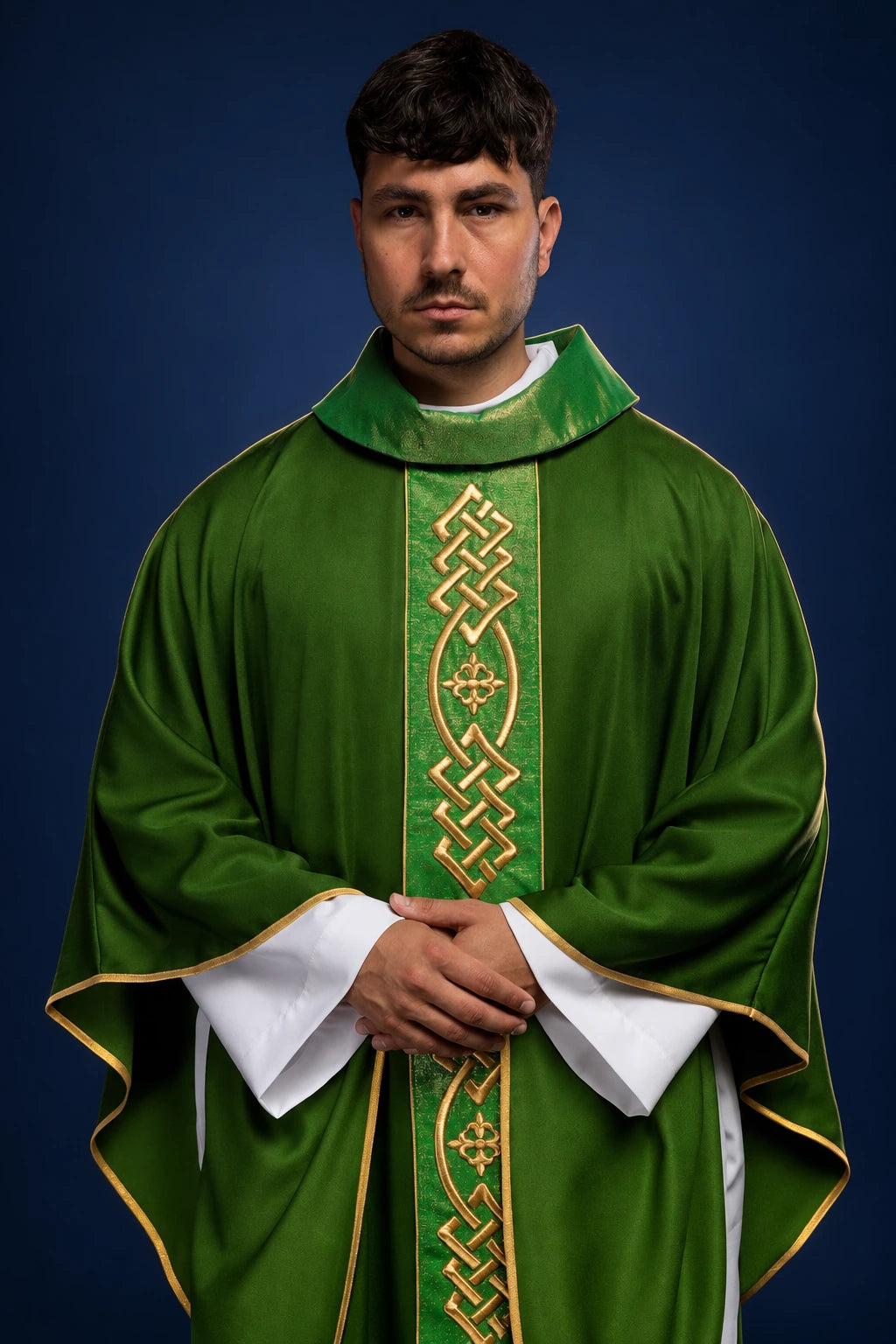 Front view of a green chasuble with gold braided orphrey and cross motifs, worn over white sleeves