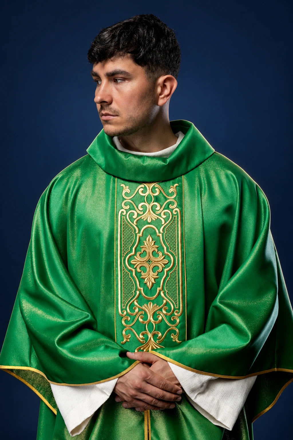 Front view of a green chasuble with gold embroidered orphrey and gold trim, worn over white vestments