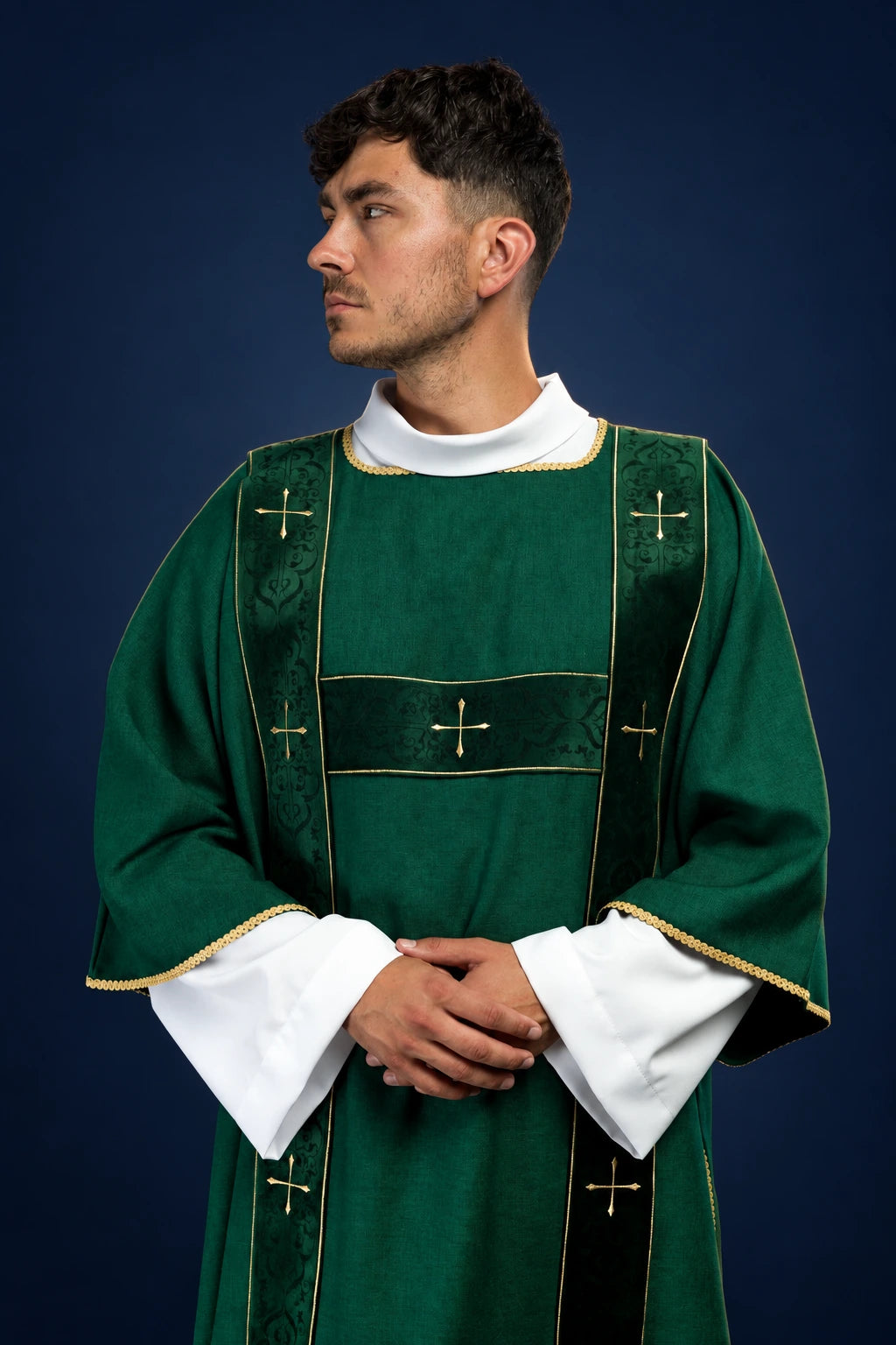 Front view of a green dalmatic with velvet vertical bands and embroidered gold crosses on the chest and sleeves