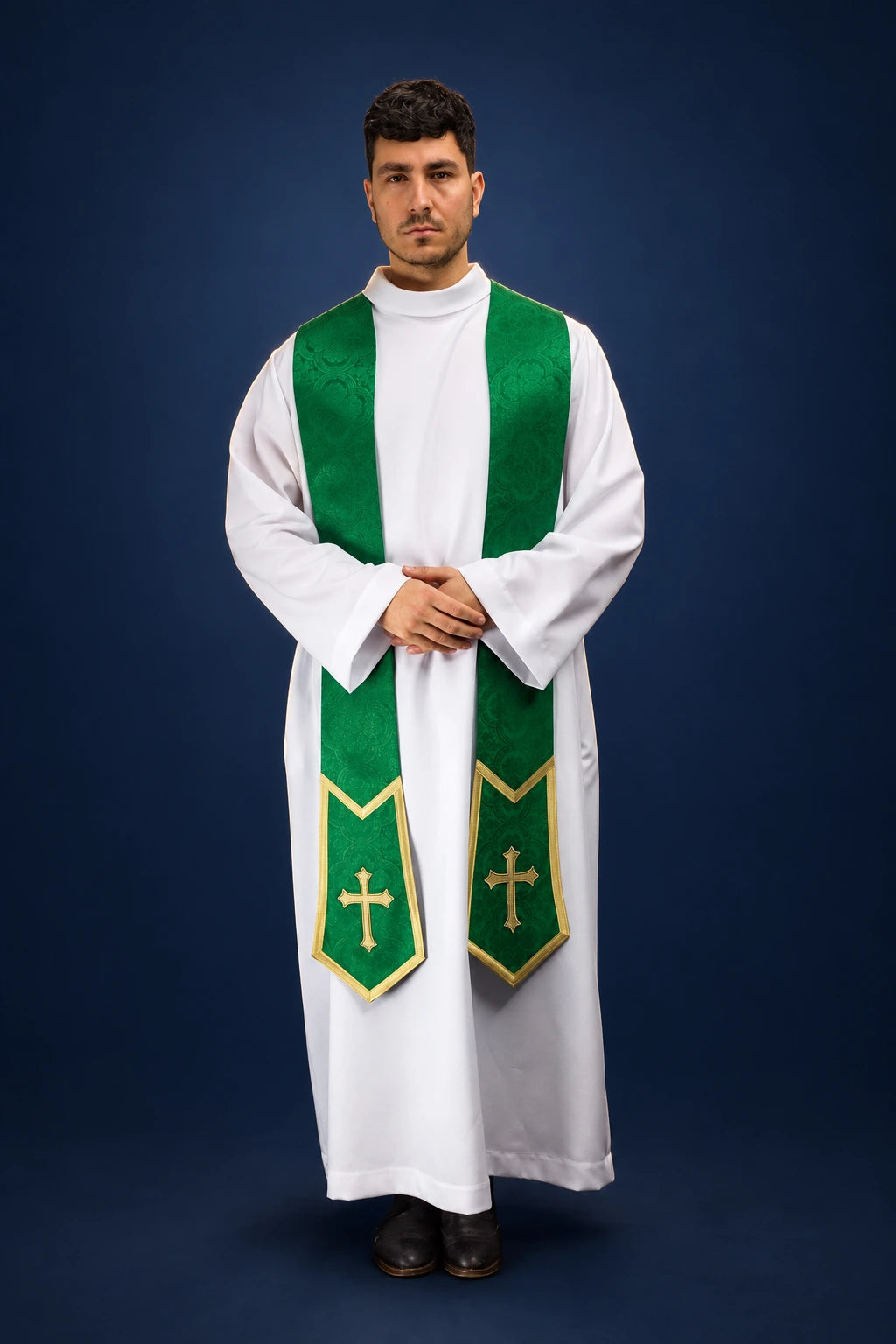 Front view of a green embroidered stole with cross motifs worn over a white vestment