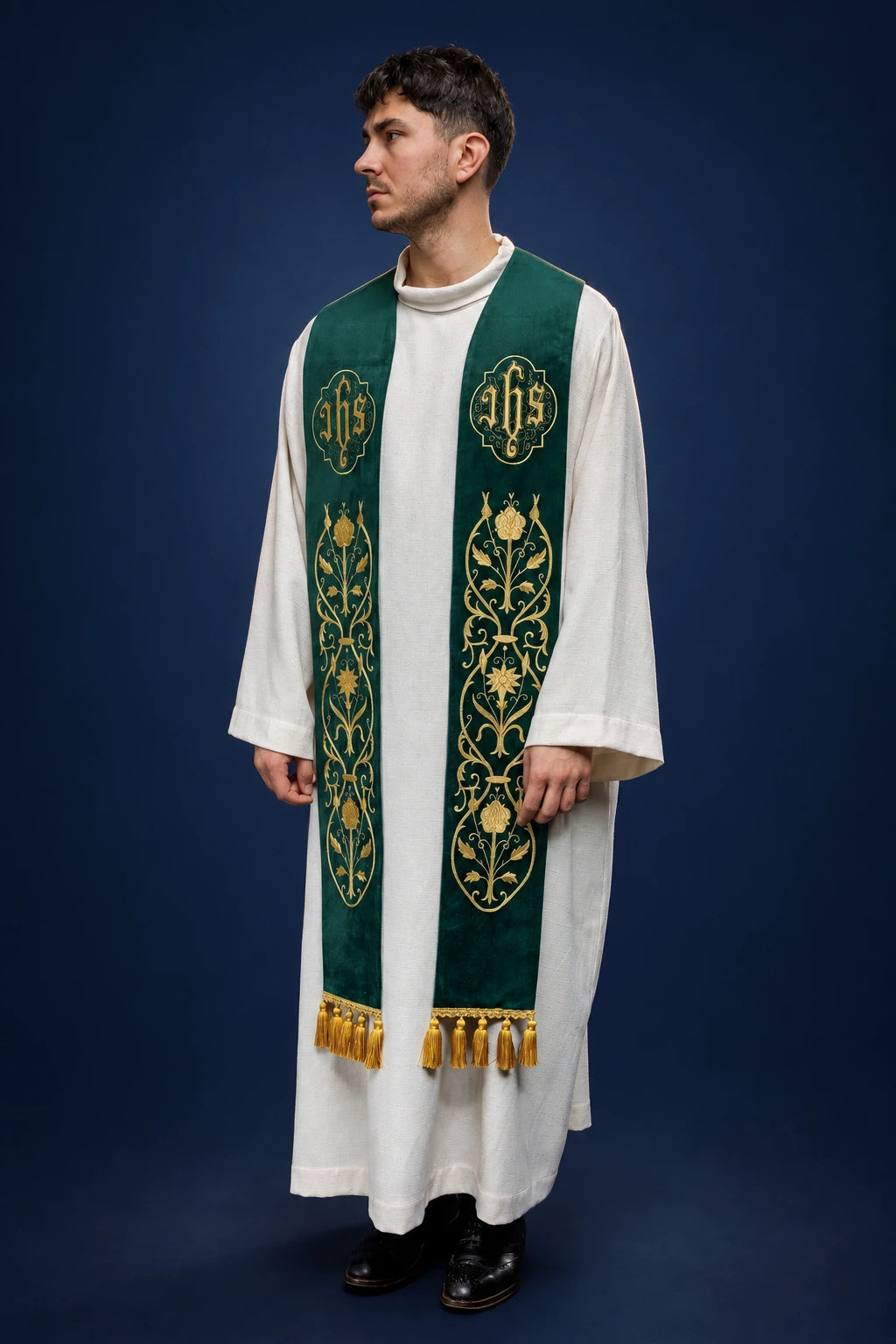 Front view of a green embroidered stole with IHS and gold tassels worn over a white alb