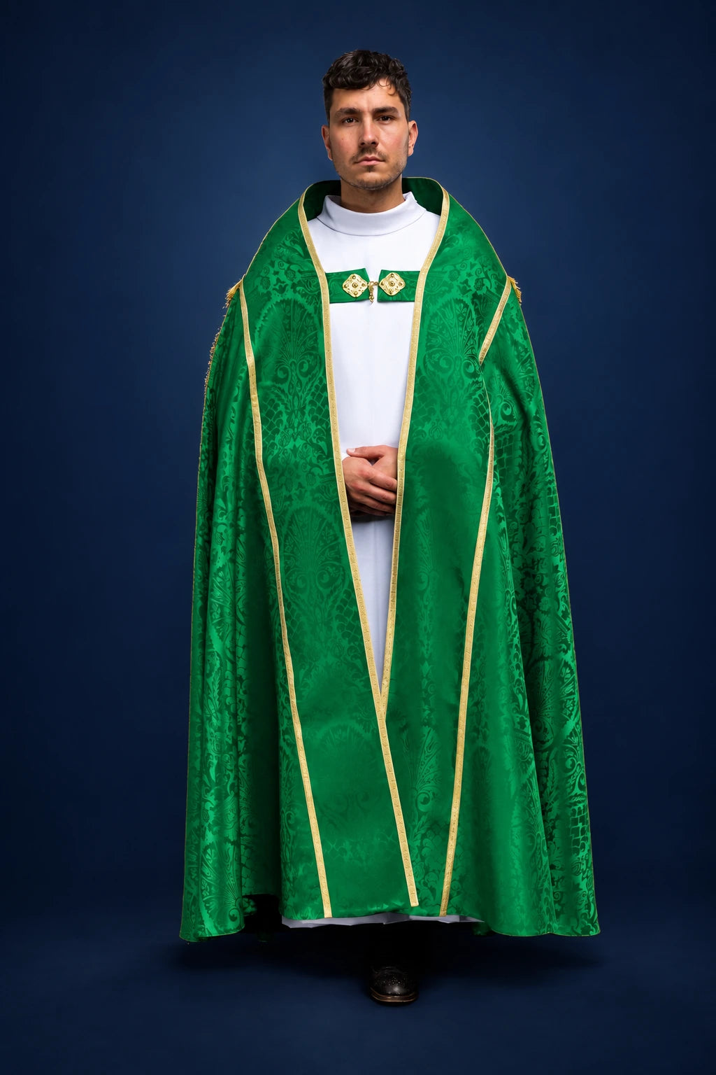 Front view of a green jacquard Roman cope with gold trim and embroidered clasp at the chest
