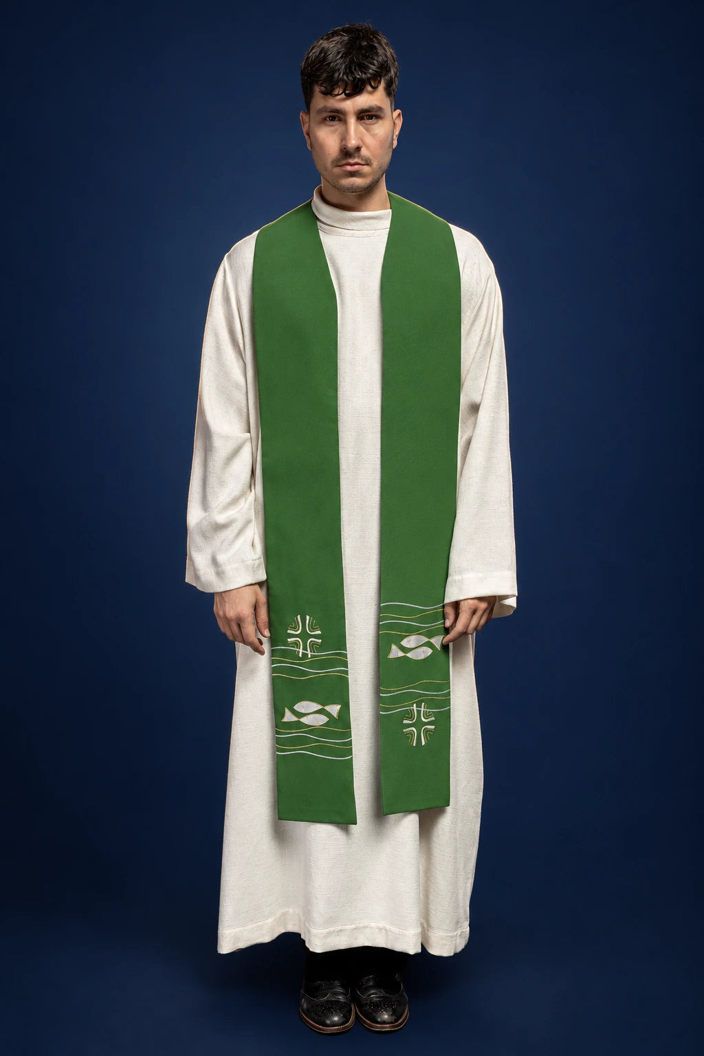 Front view of a green priest stole with Ichthys fish and cross embroidery over a white alb