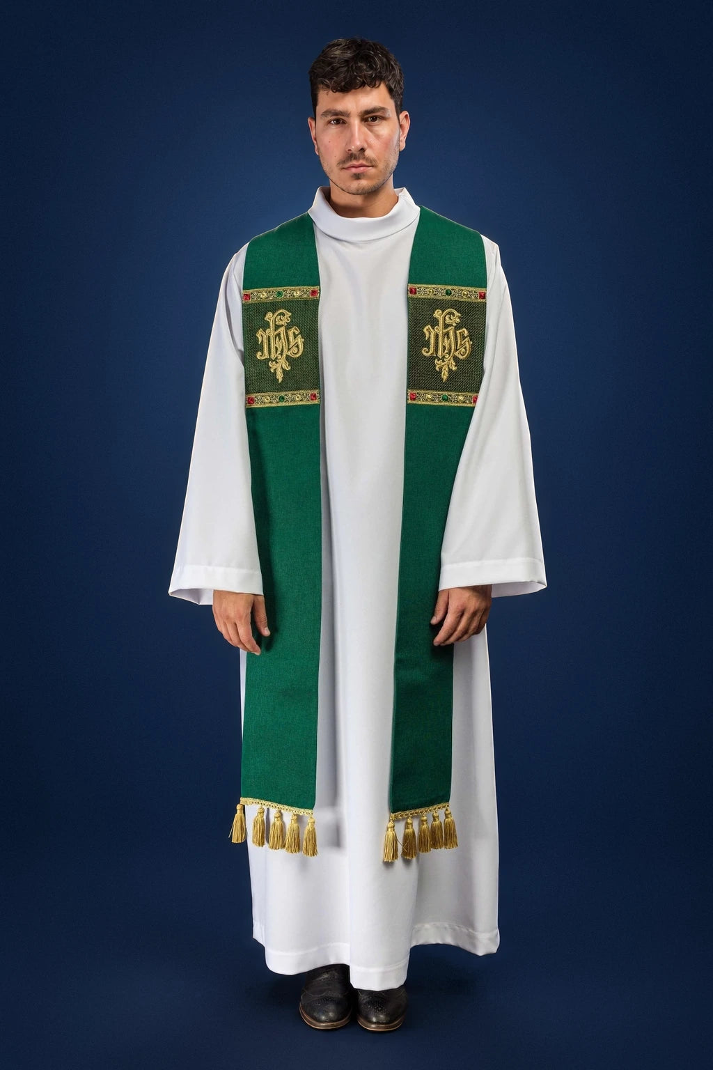 Front view of a green stole with IHS embroidery and gold fringe, worn over a white alb