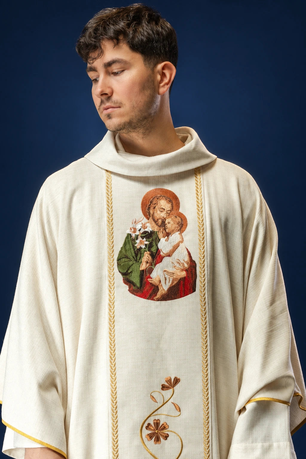 Front view of an ivory chasuble with a central embroidered Saint Joseph and Child motif.