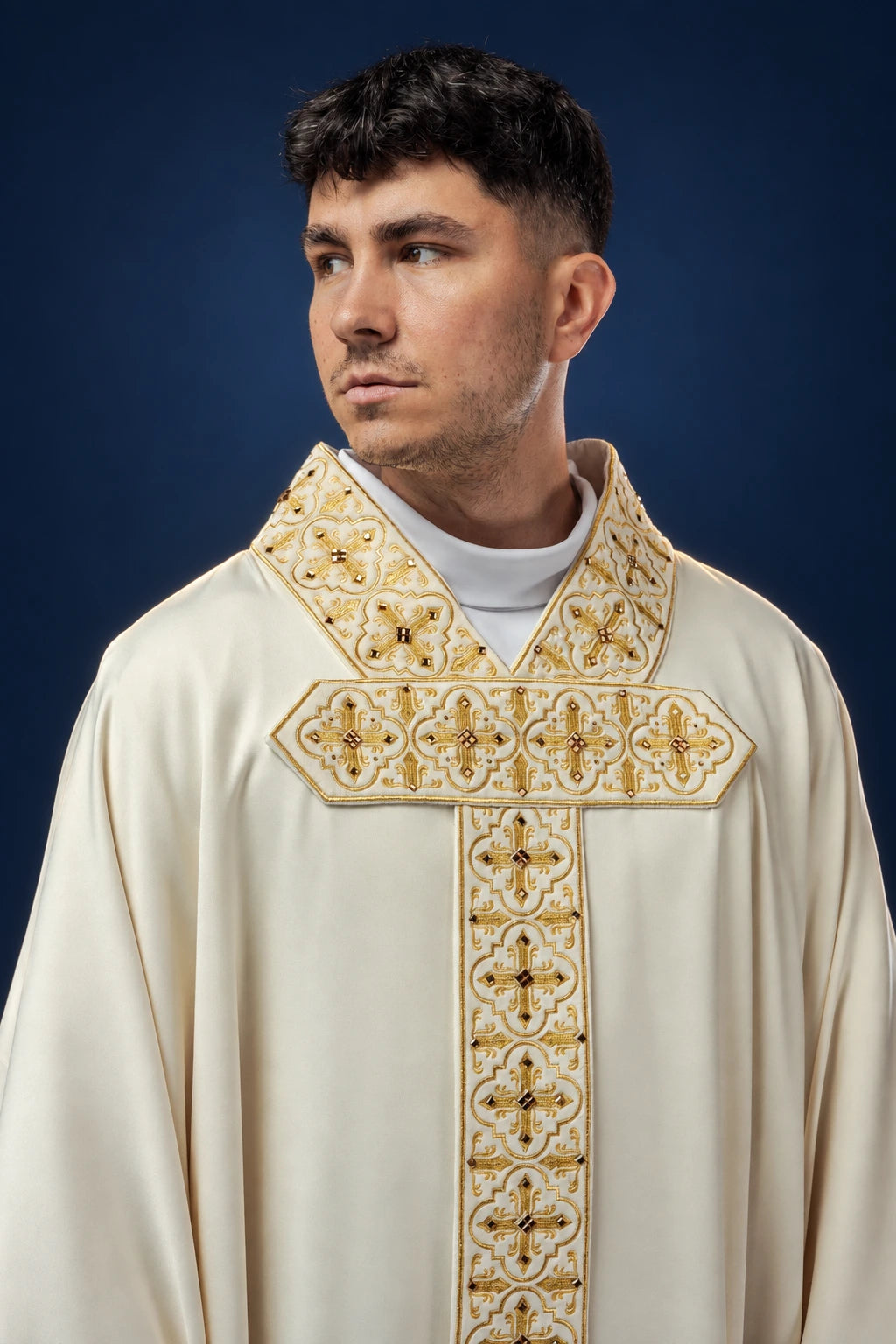 Front view of an ivory chasuble with gold embroidered hanging orphrey and cross motifs with stones