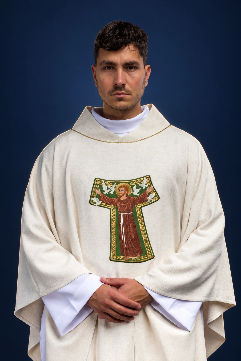 Front view of an ivory chasuble with hooded collar and embroidered Saint Francis image on the chest