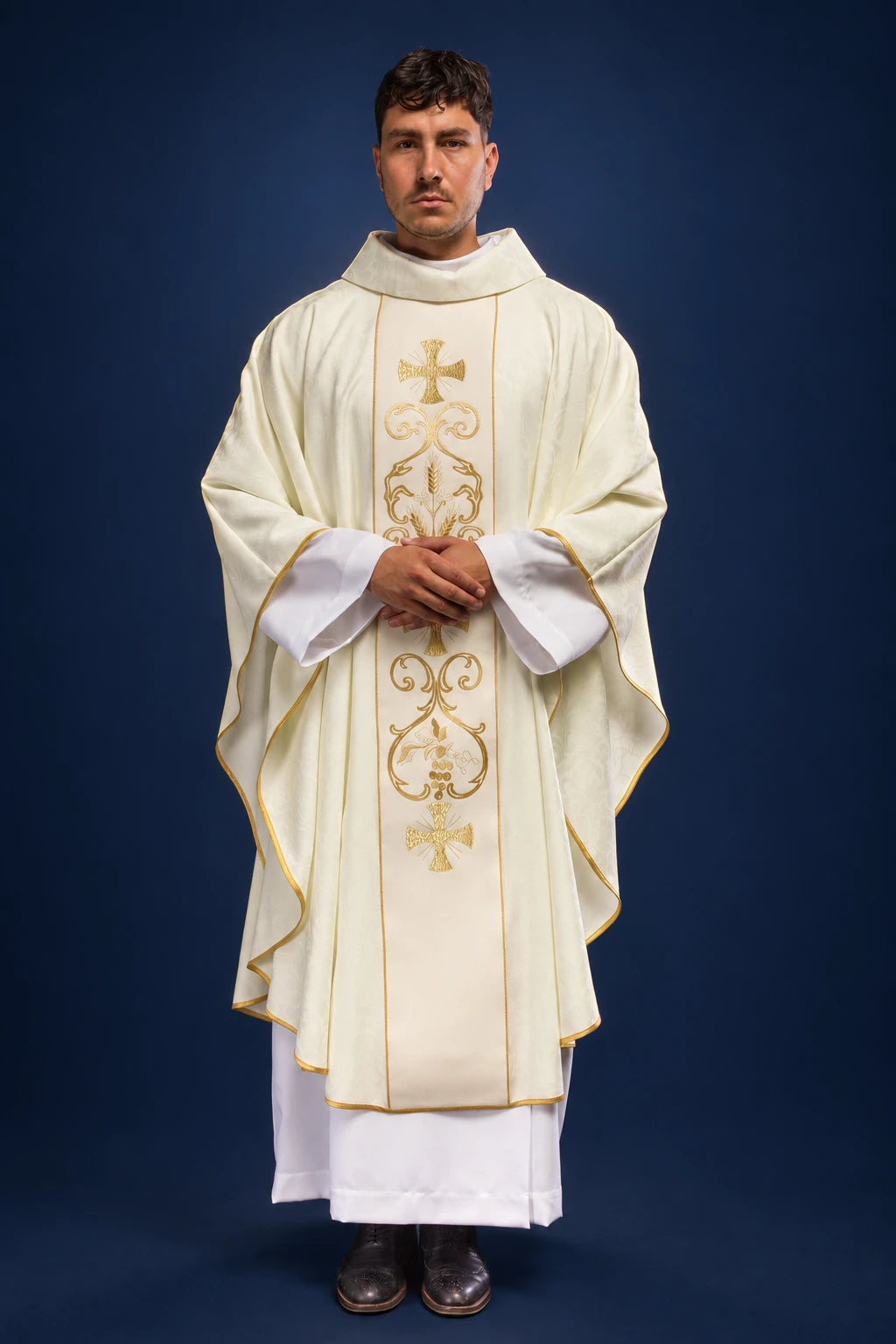 Front view of ivory liturgical chasuble with gold embroidered orphrey and trim, worn over a white alb