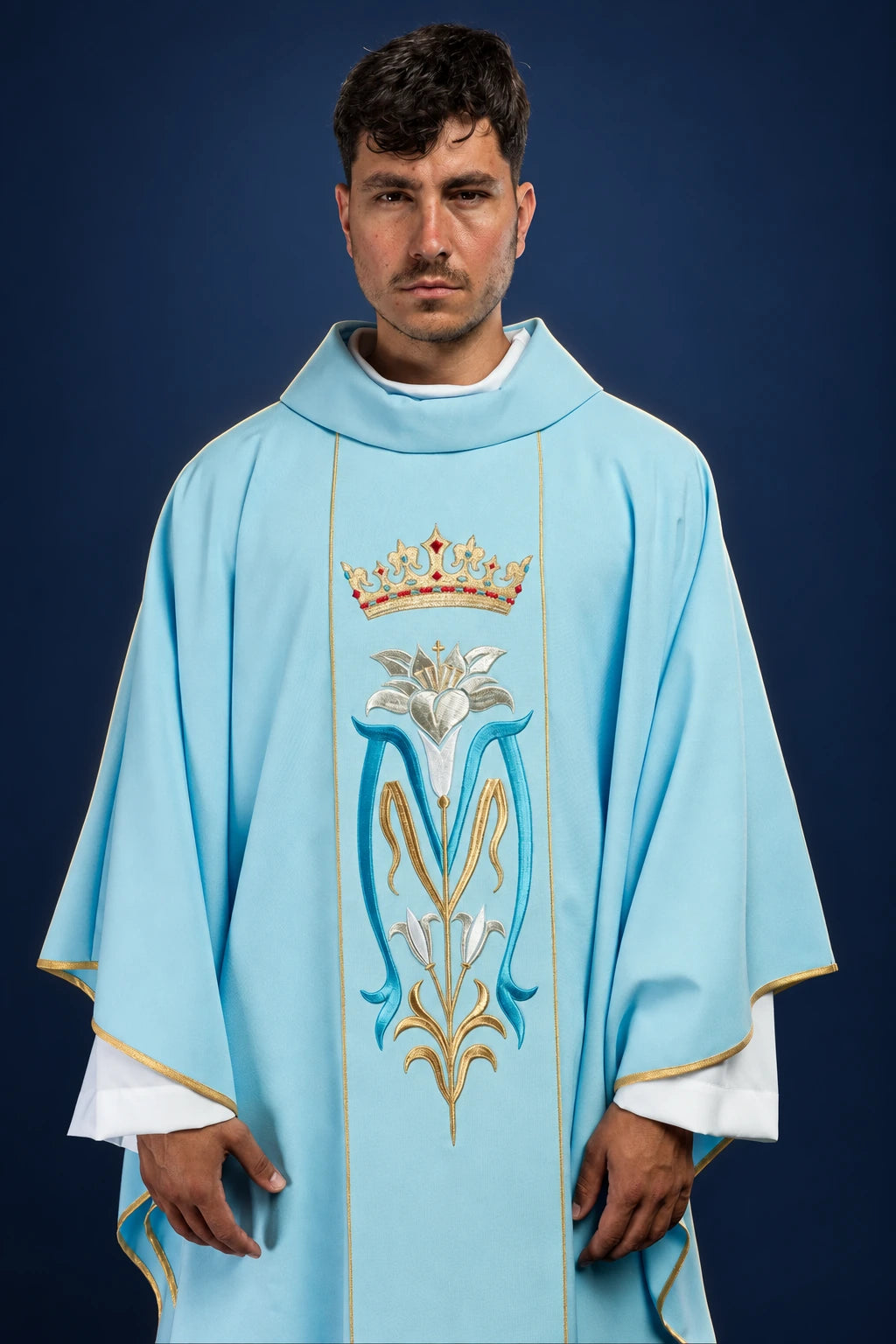 Front view of a light blue chasuble with a crowned Marian monogram and gold trim