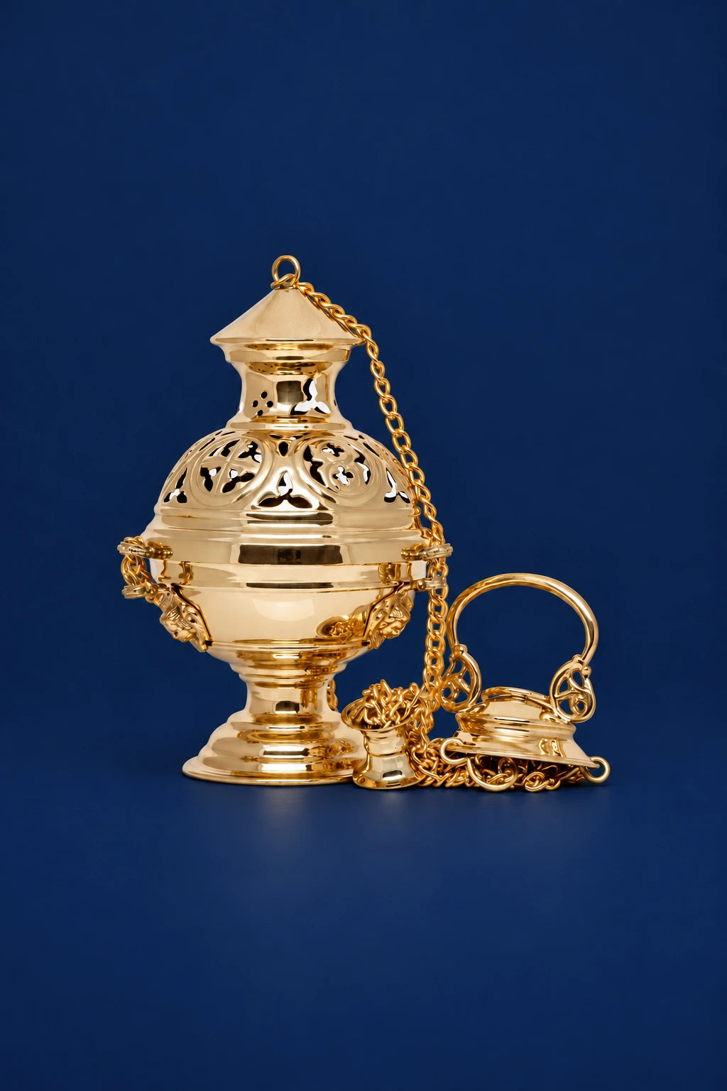 Front view of a polished brass thurible with pierced floral band, chain, and matching small lid on the side