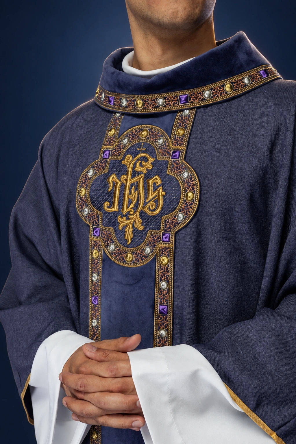 Front view of a purple chasuble with embroidered IHS orphrey and jeweled trim