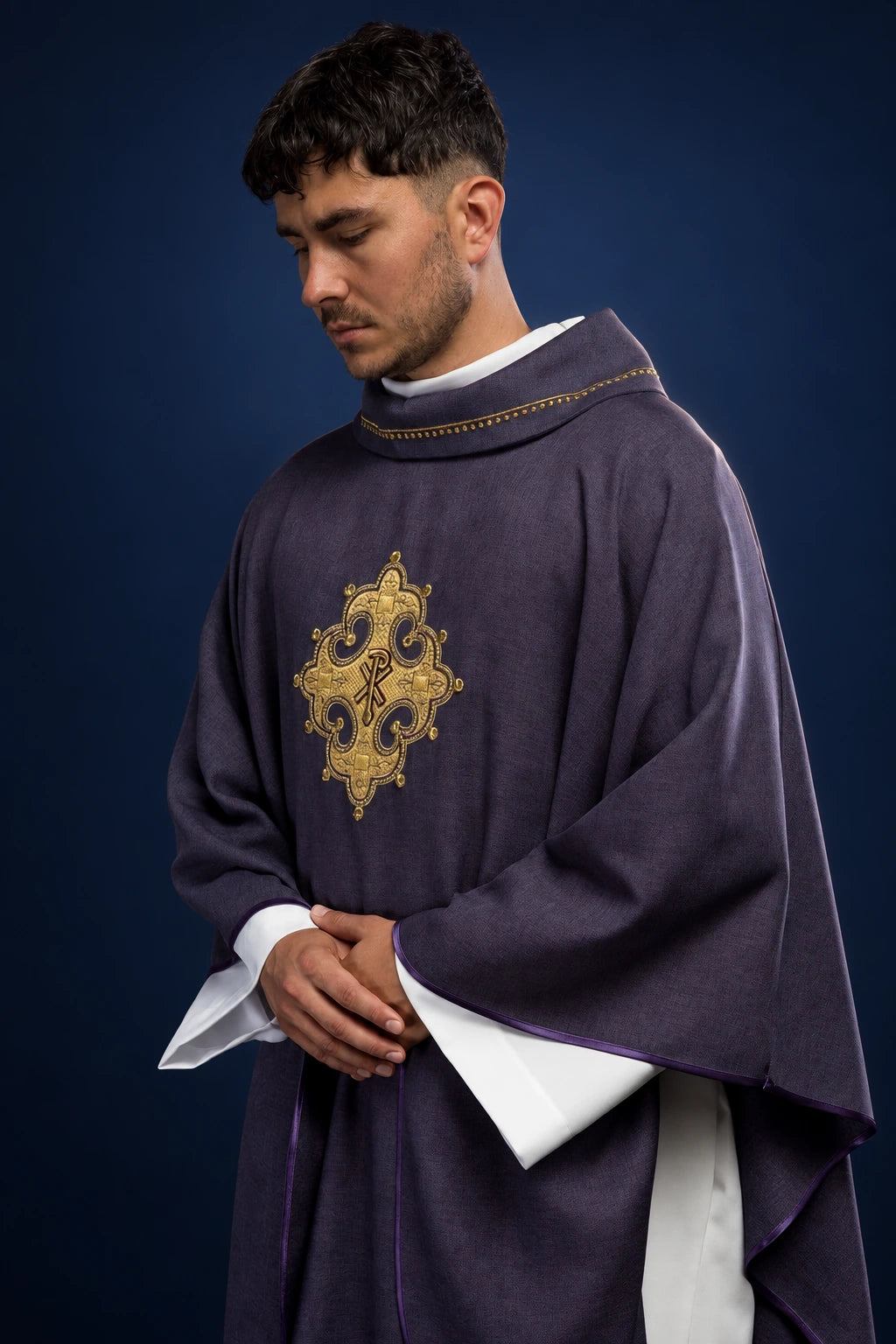 Front view of a purple chasuble with gold collar trim and ornate embroidered cross medallion