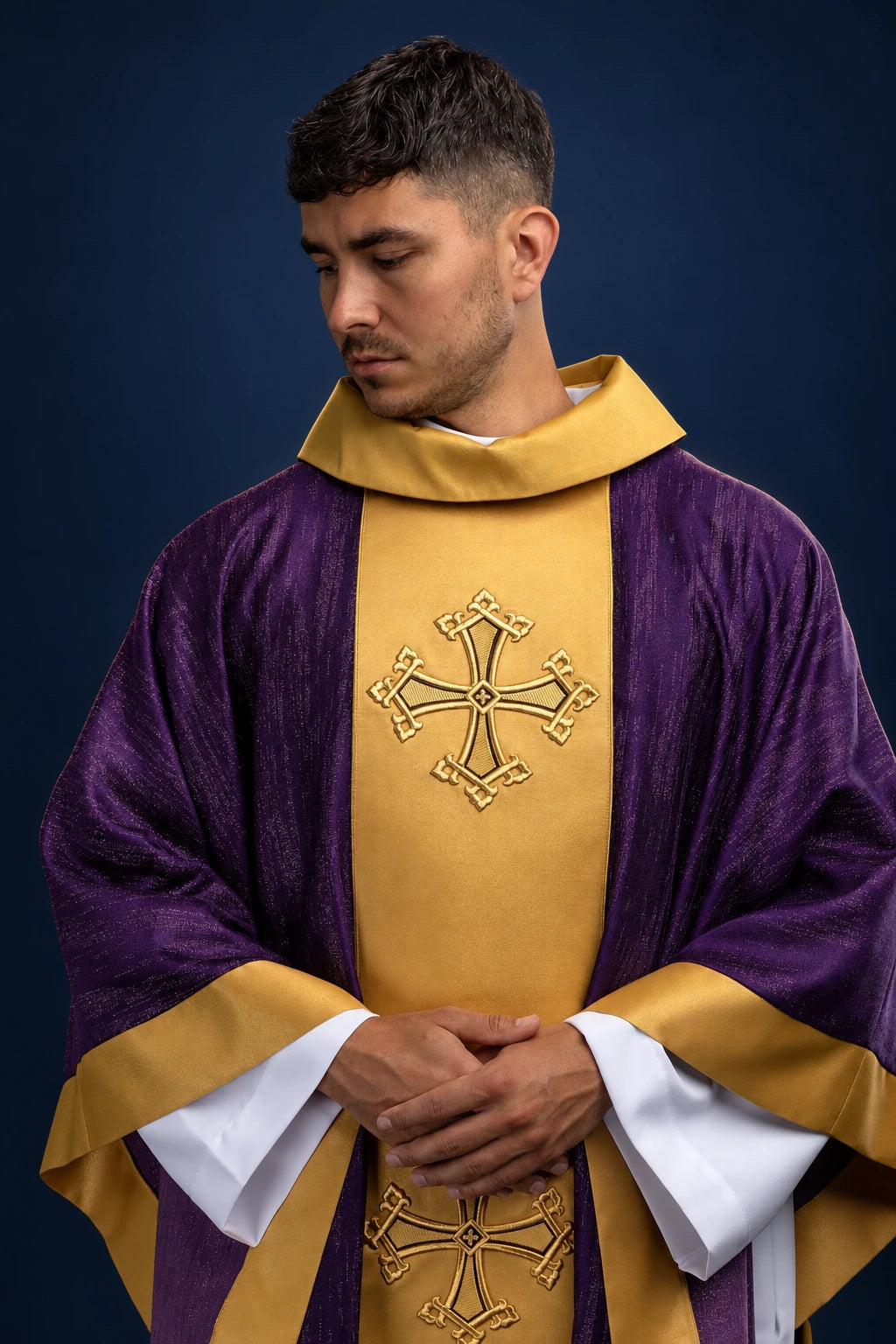 Front view of a purple chasuble with gold orphrey and embroidered cross motifs.