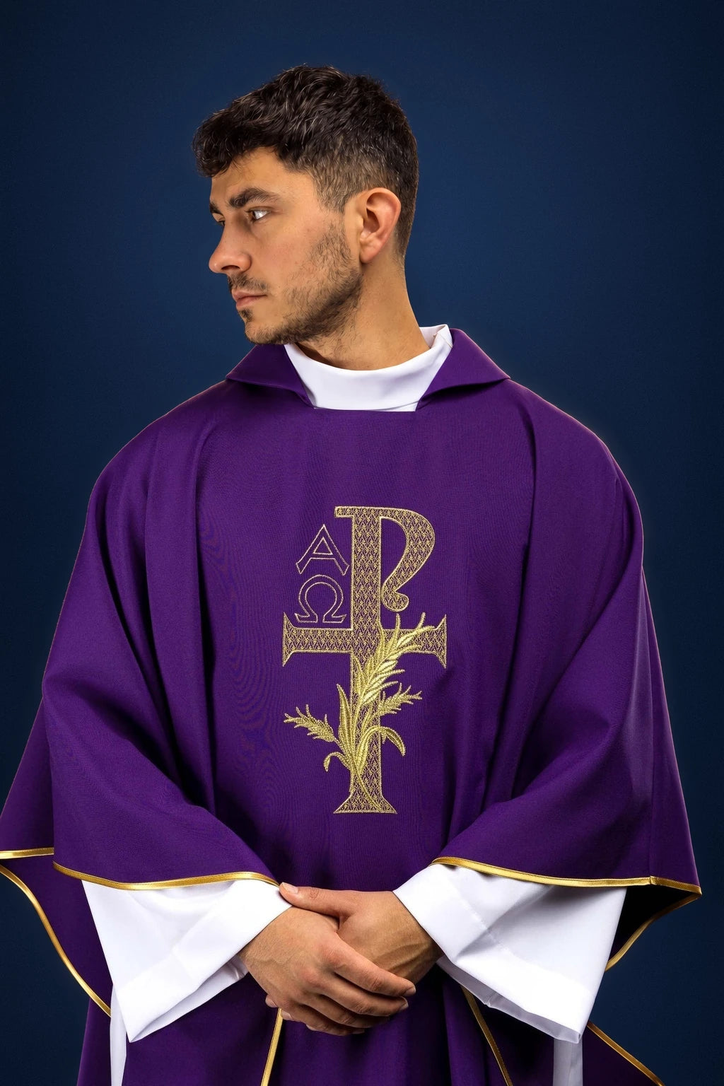 Front view of a purple chasuble with wide collar and gold Alpha Omega embroidery on the chest