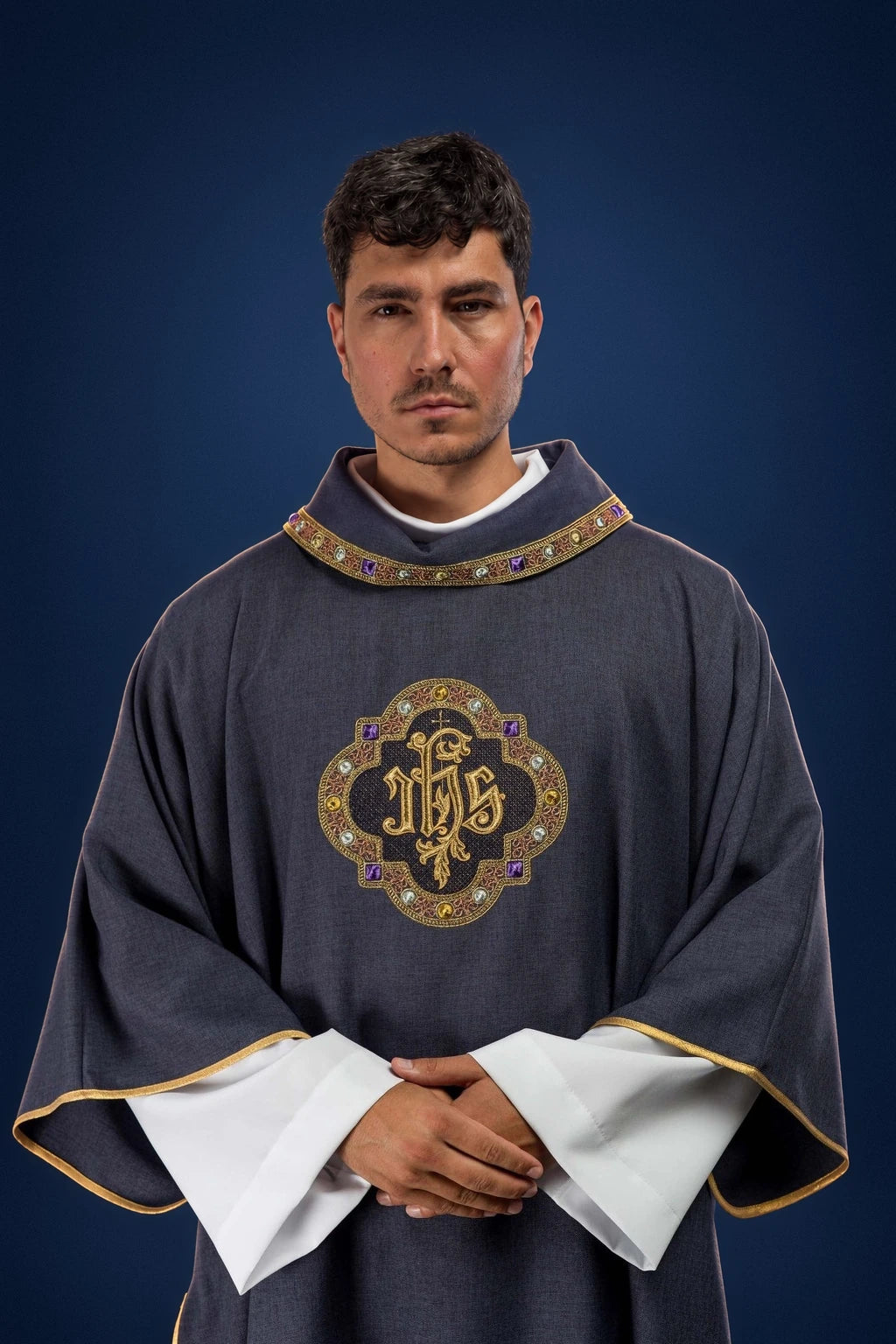 Front view of a purple dalmatic with gold-trimmed collar and central IHS medallion embroidery
