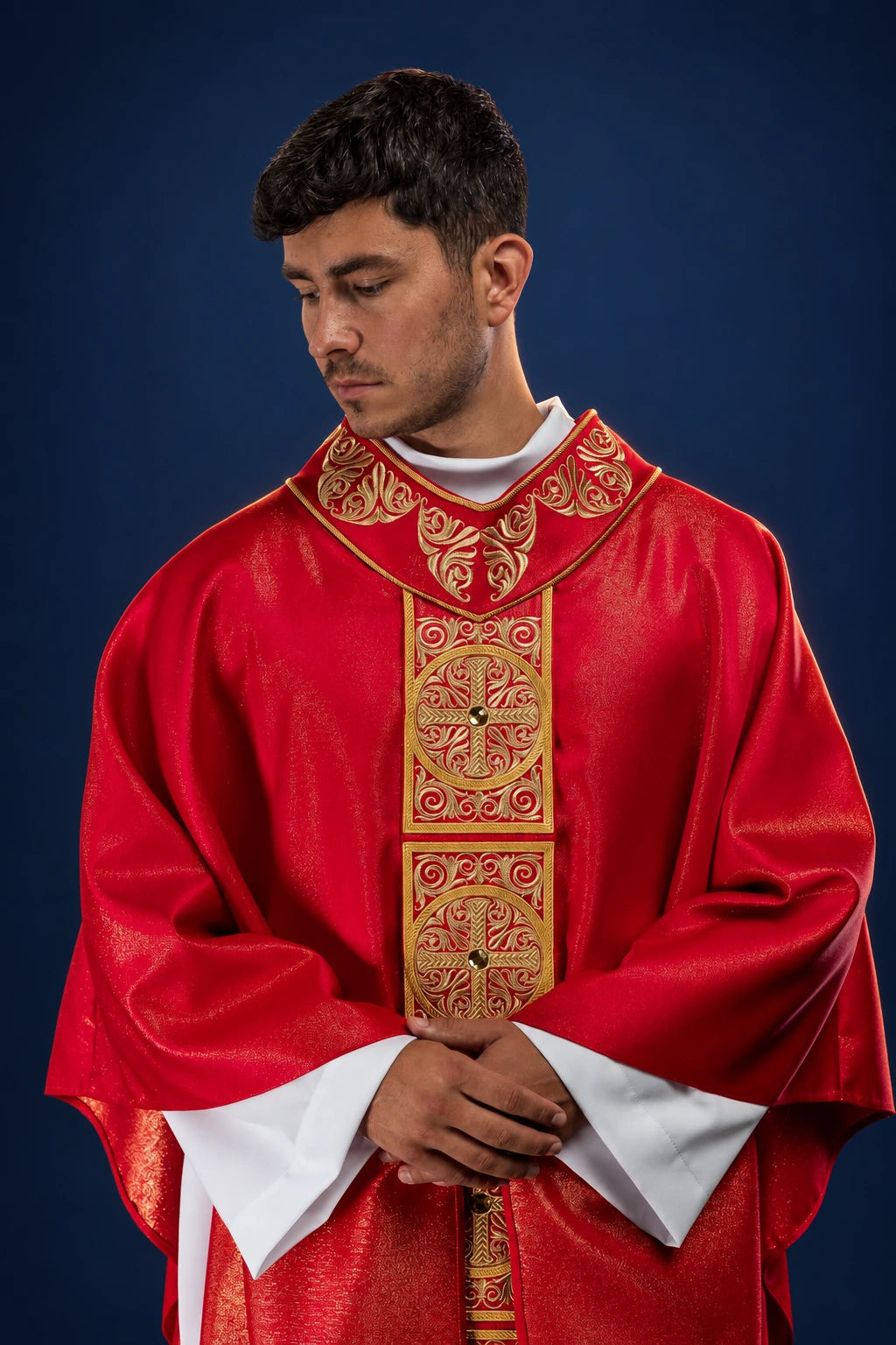 Front view of a red chasuble with embroidered orphrey and gold cross medallions with stones