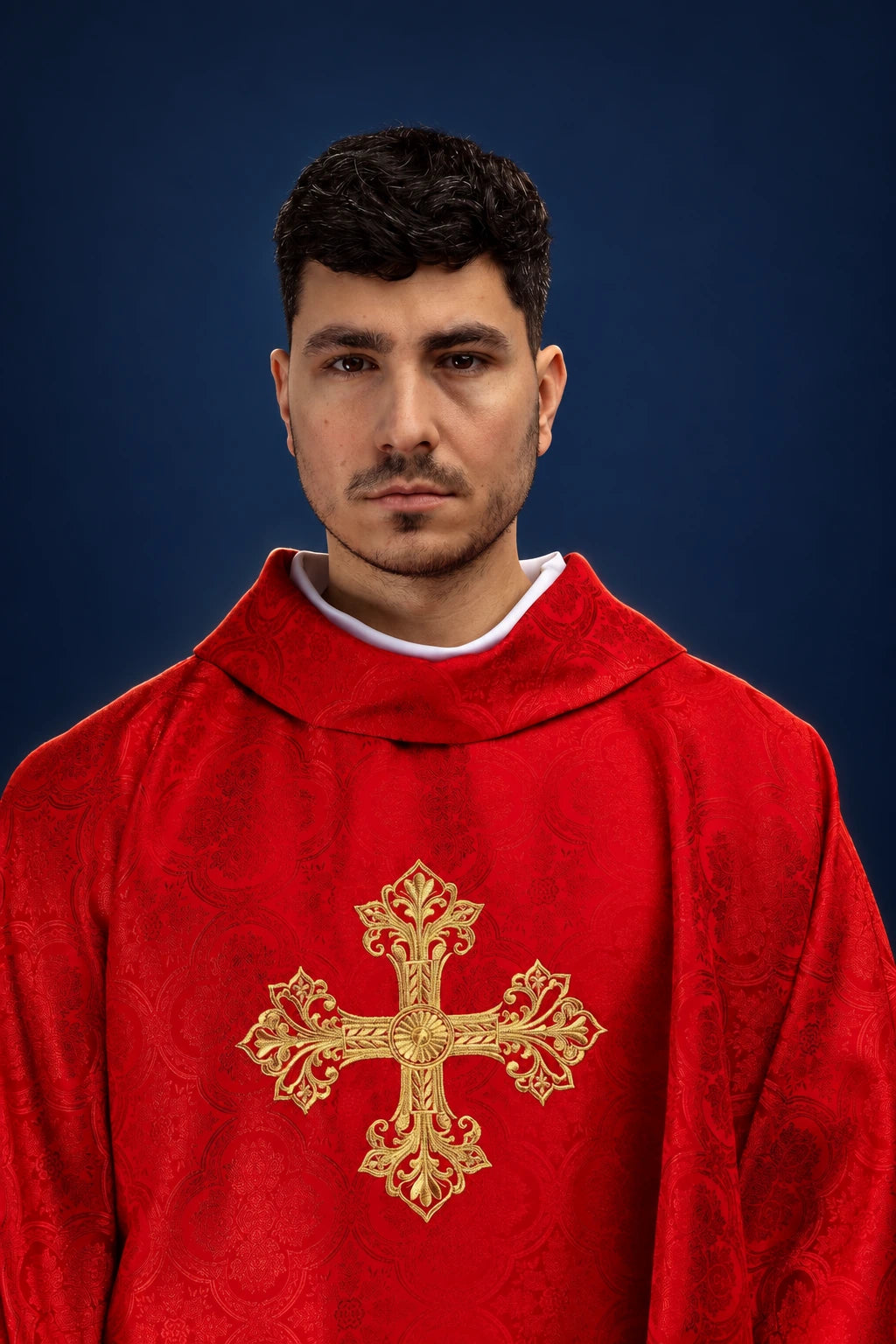 Front view of a red chasuble with a gold cross motif on the chest and jacquard fabric texture