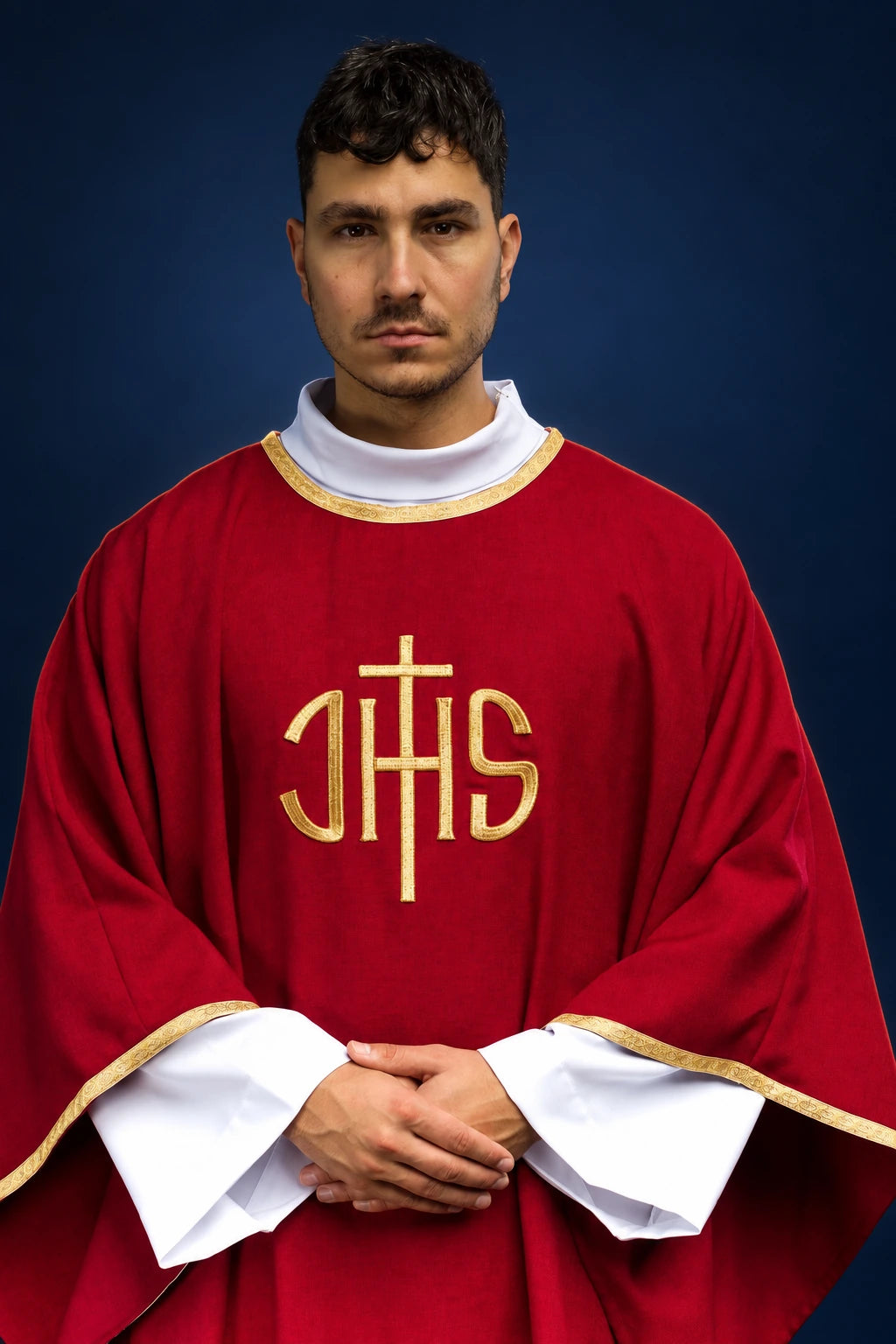 Front view of a red chasuble with gold trim and central gold IHS embroidery