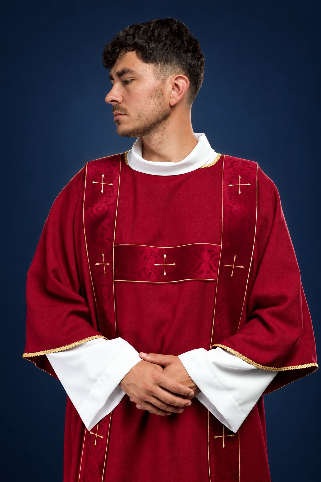 Front view of a red dalmatic with velvet bands and embroidered gold crosses