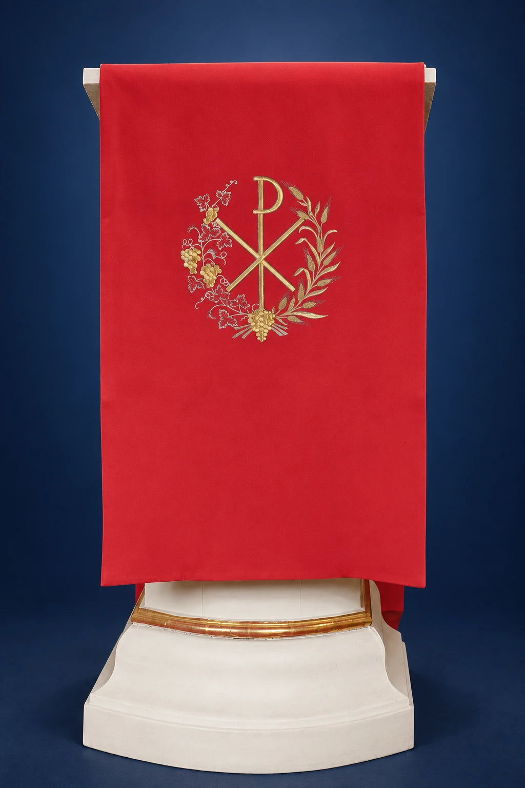 Front view of a red lectern cover with gold PAX embroidery and vine motif