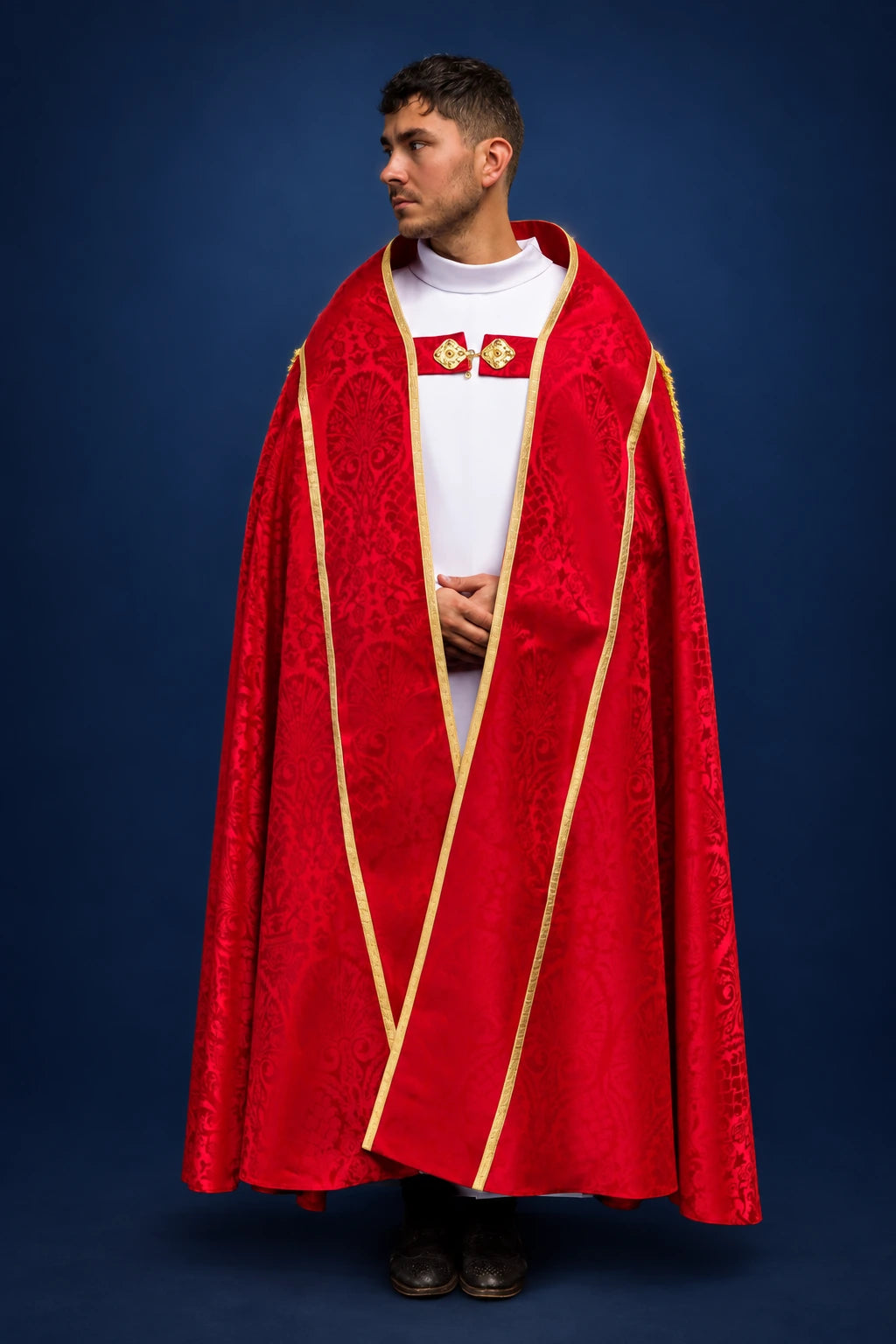 Front view of a red Roman cope with gold trim and embroidered orphrey panels