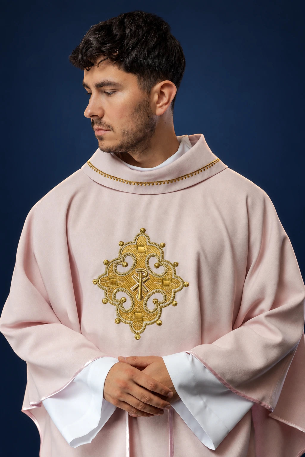 Front view of a rose chasuble with a gold embroidered cross and gold-trimmed collar