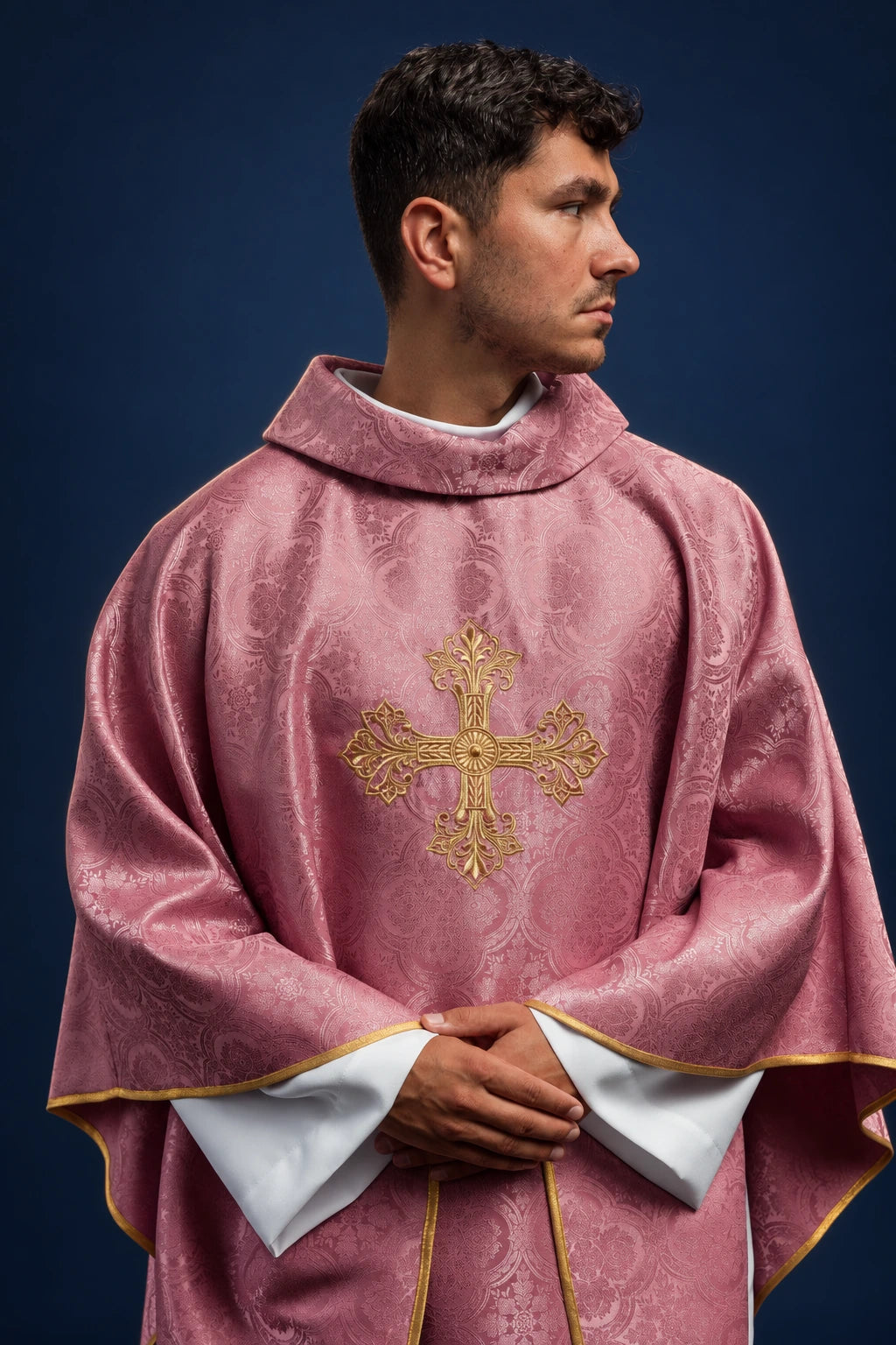 Front view of a rose chasuble with patterned fabric and gold cross embroidery