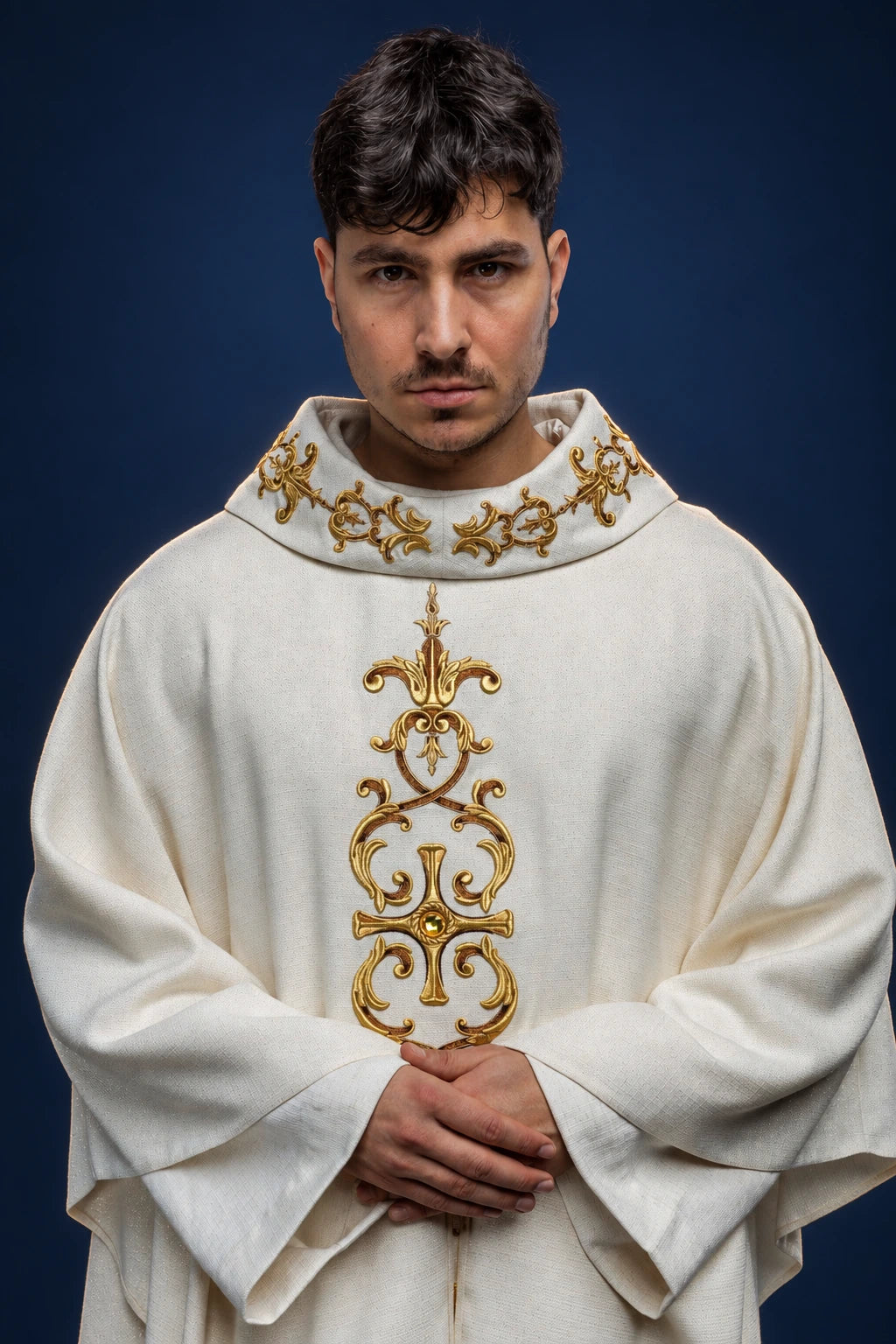 Front view of a white chasuble with gold embroidered collar and ornate vertical gold motif on the chest