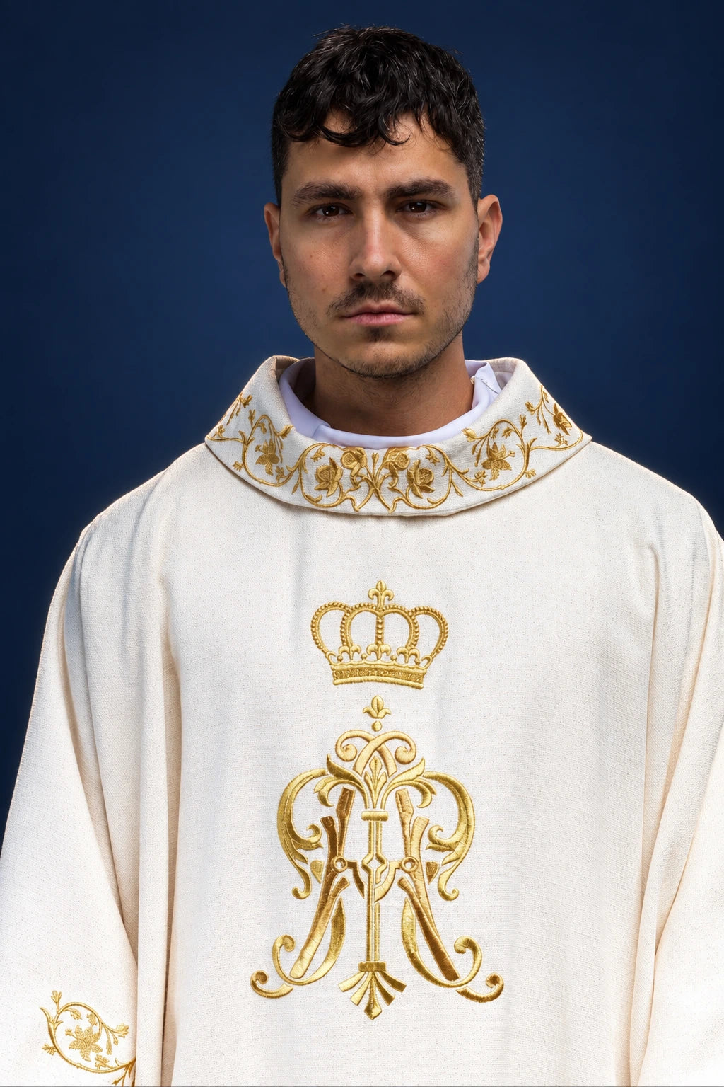 Front view of white chasuble with gold Marian monogram and embroidered collar trim