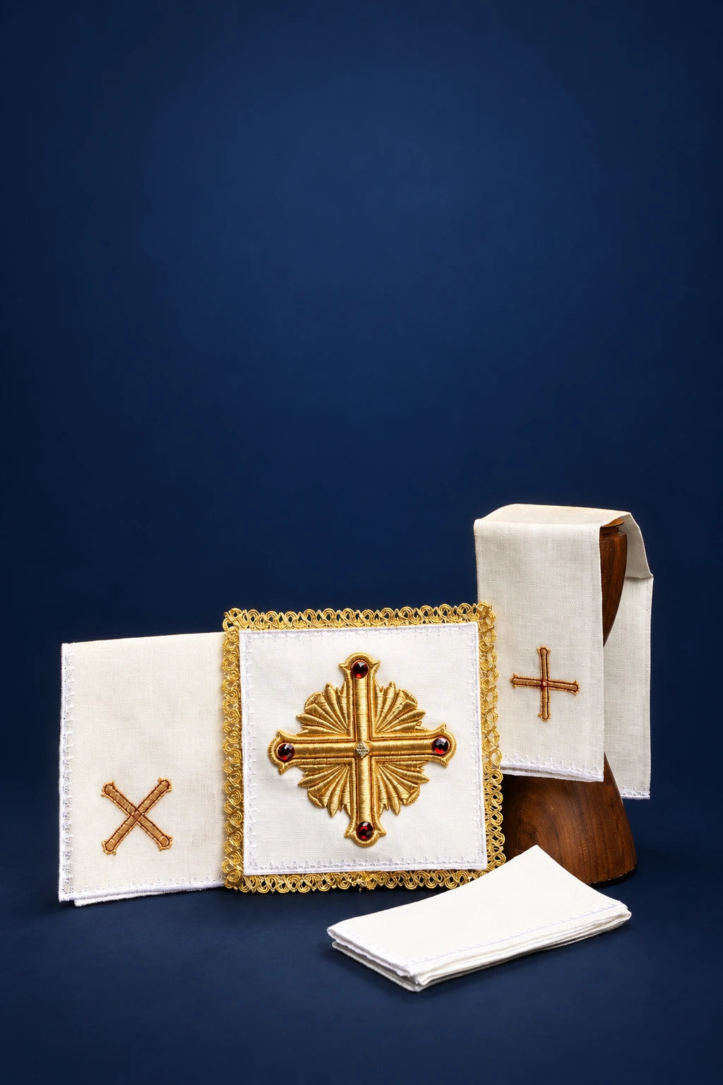 Front view of a white linen altar linen set with gold-embroidered crosses and central medallion detail